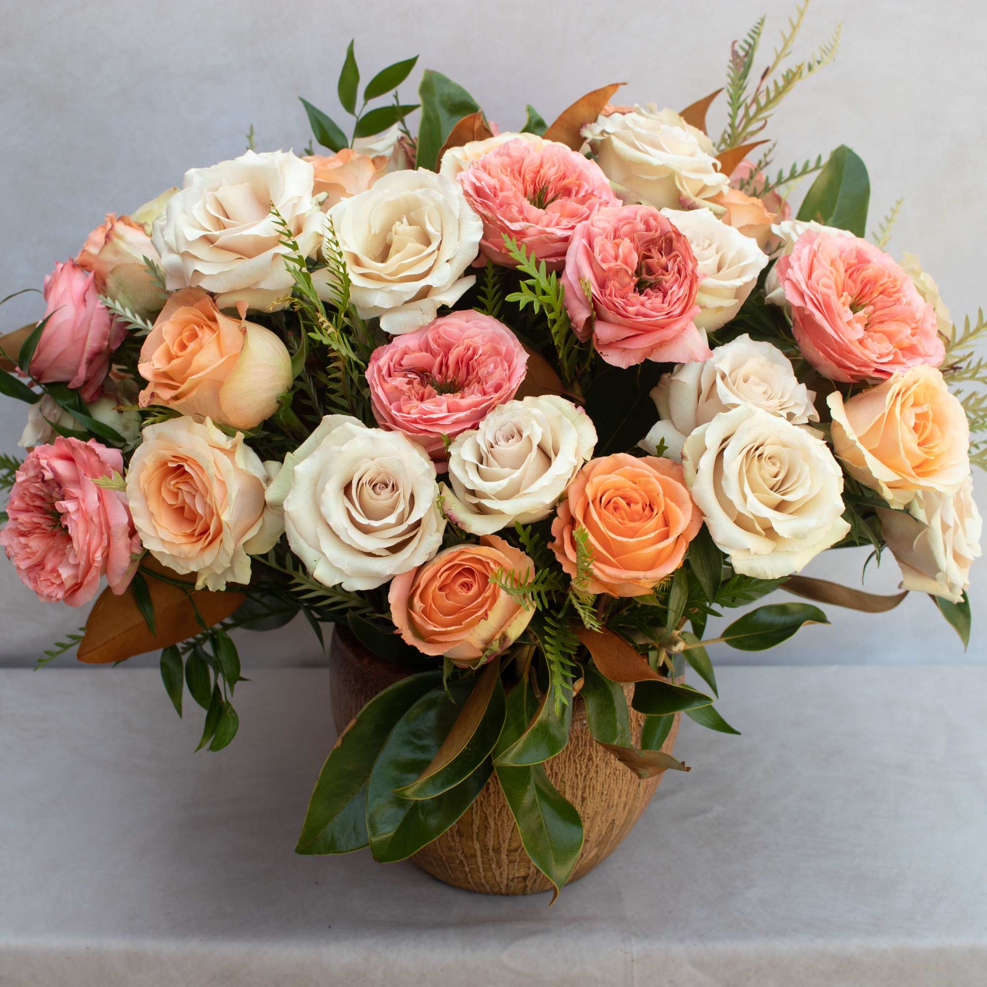 BOUQUET OF MIXED ROSES IN A GLAZED TERRACOTTA CONTAINER. 
ARRAY OF ROSES