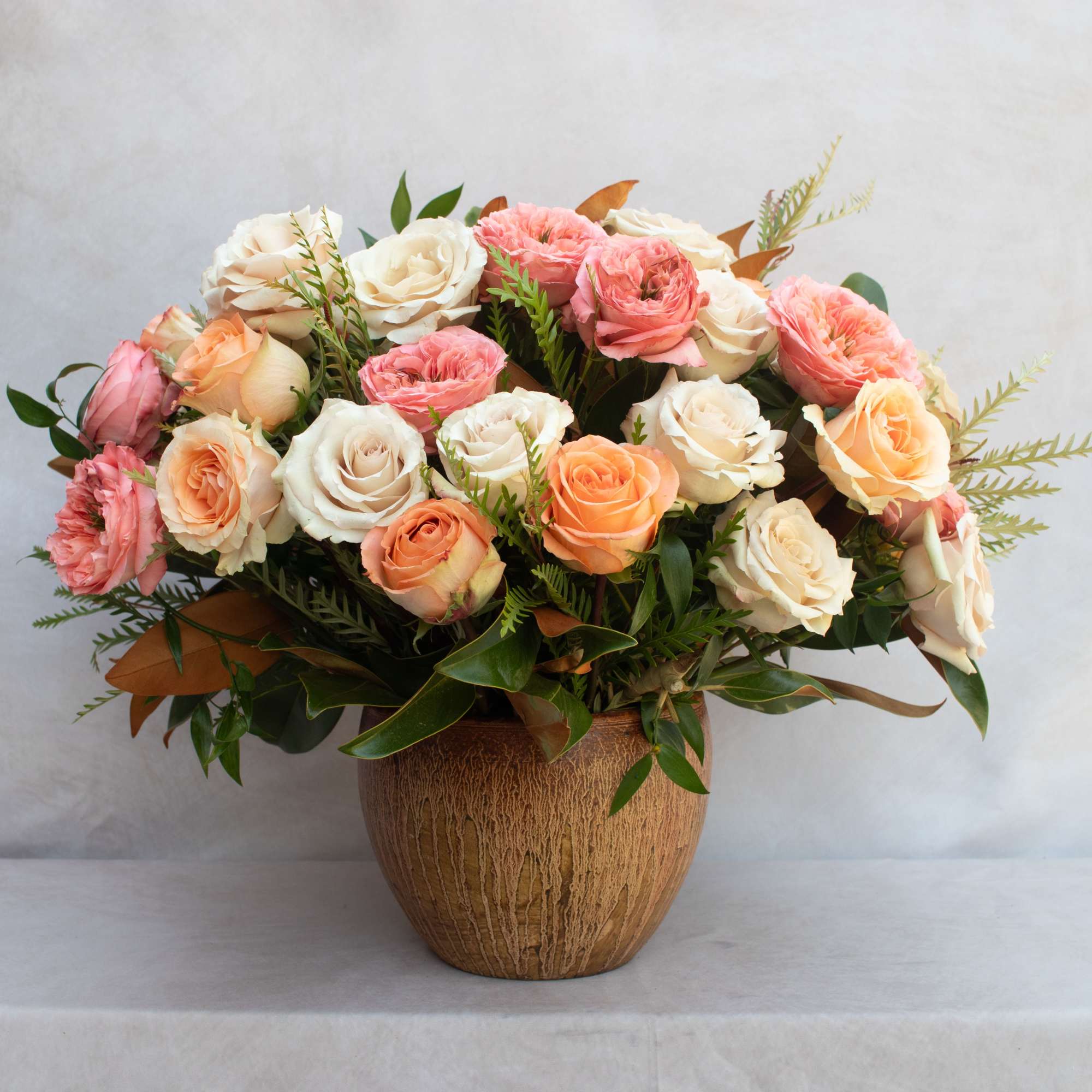 BOUQUET OF MIXED ROSES IN A GLAZED TERRACOTTA CONTAINER. 
ARRAY OF ROSES