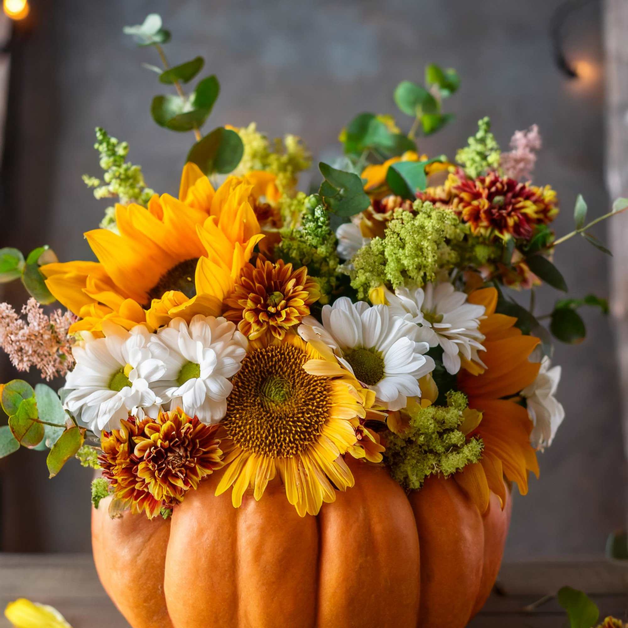 This exquisite floral arrangement showcases rich, warm hues and delicate flowers arranged