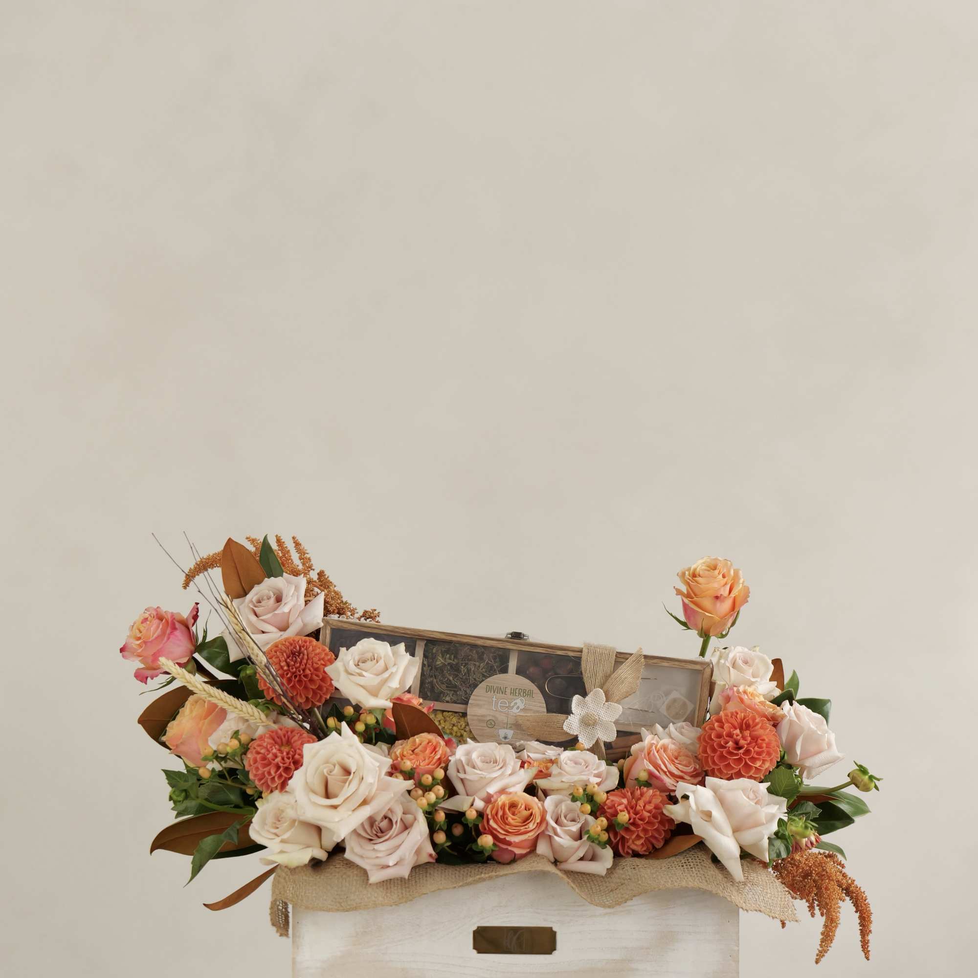 An elegant floral gift box featuring nude and peach roses with seasonal An elegant floral gift box featuring nude and peach roses with seasonal