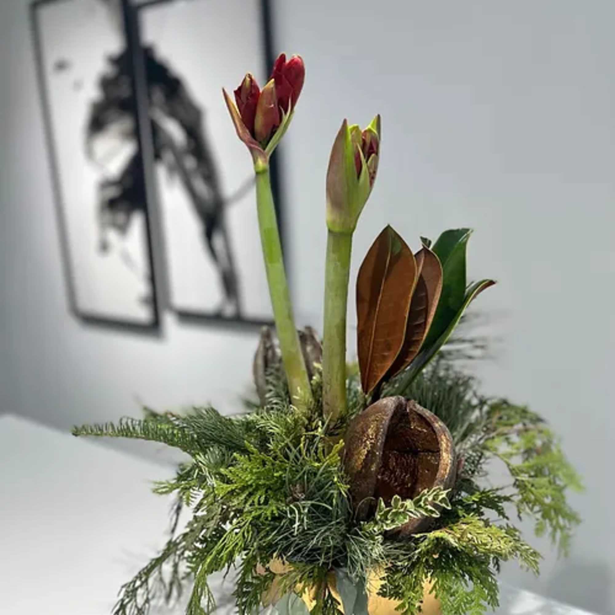 Gold ceramic pot dressed with fragrant holiday greens wrapped around a single