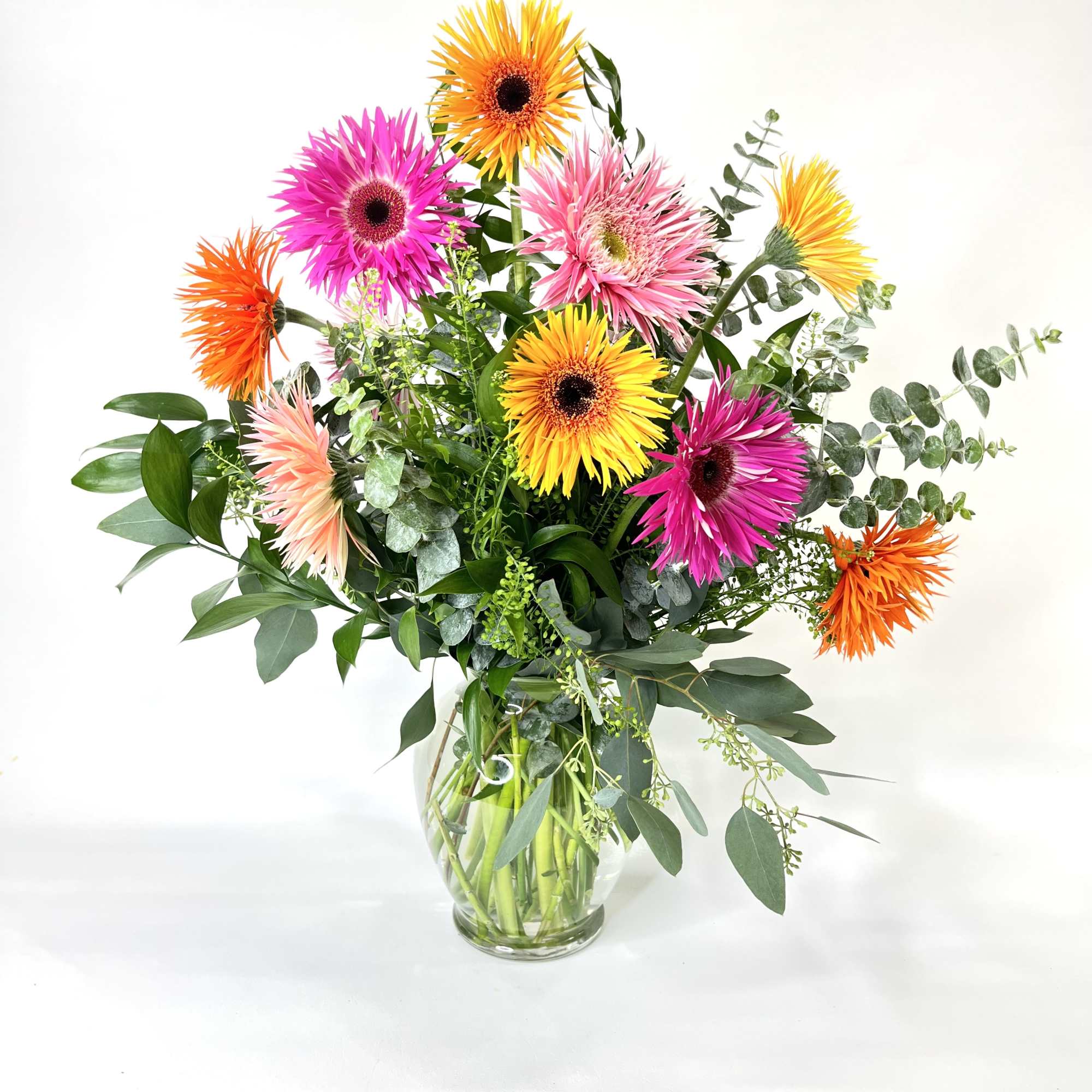 All gerbera daisys in mixed colors with ruckus and eucalyptus greens in