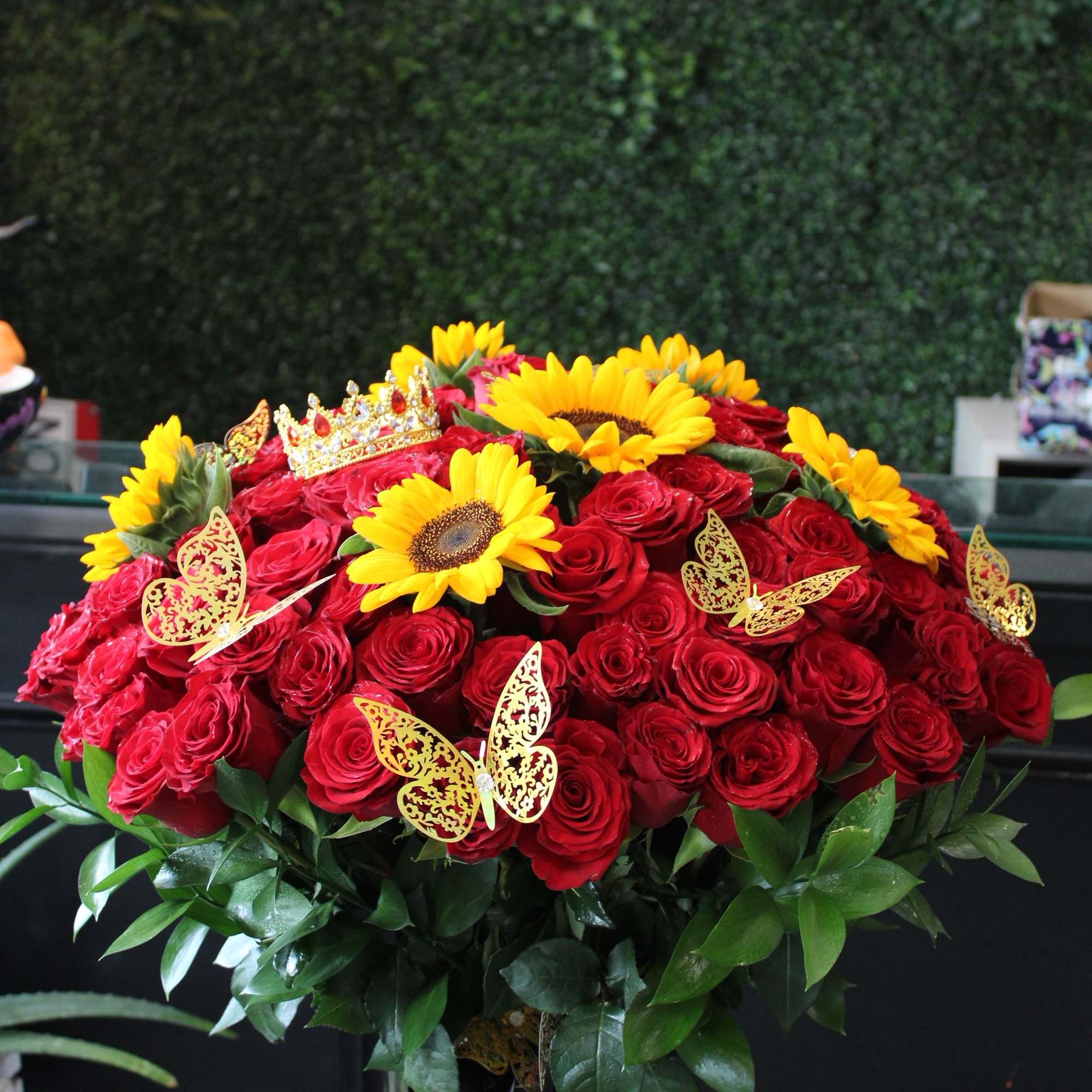 100 red premium roses , sunflowers and golden butterflies, medium gold crown.