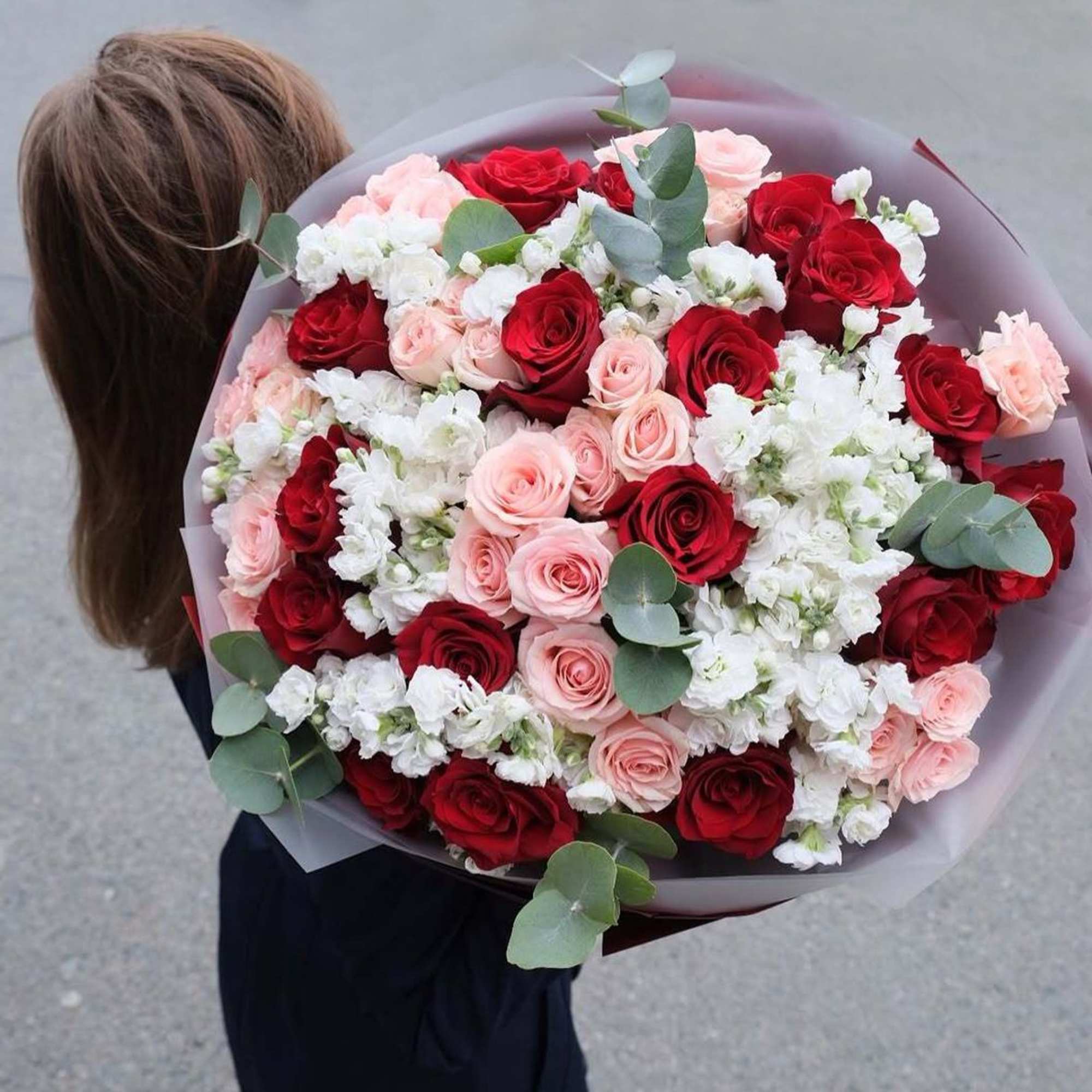 A stunning bouquet of fresh red roses, white stock flower and pink