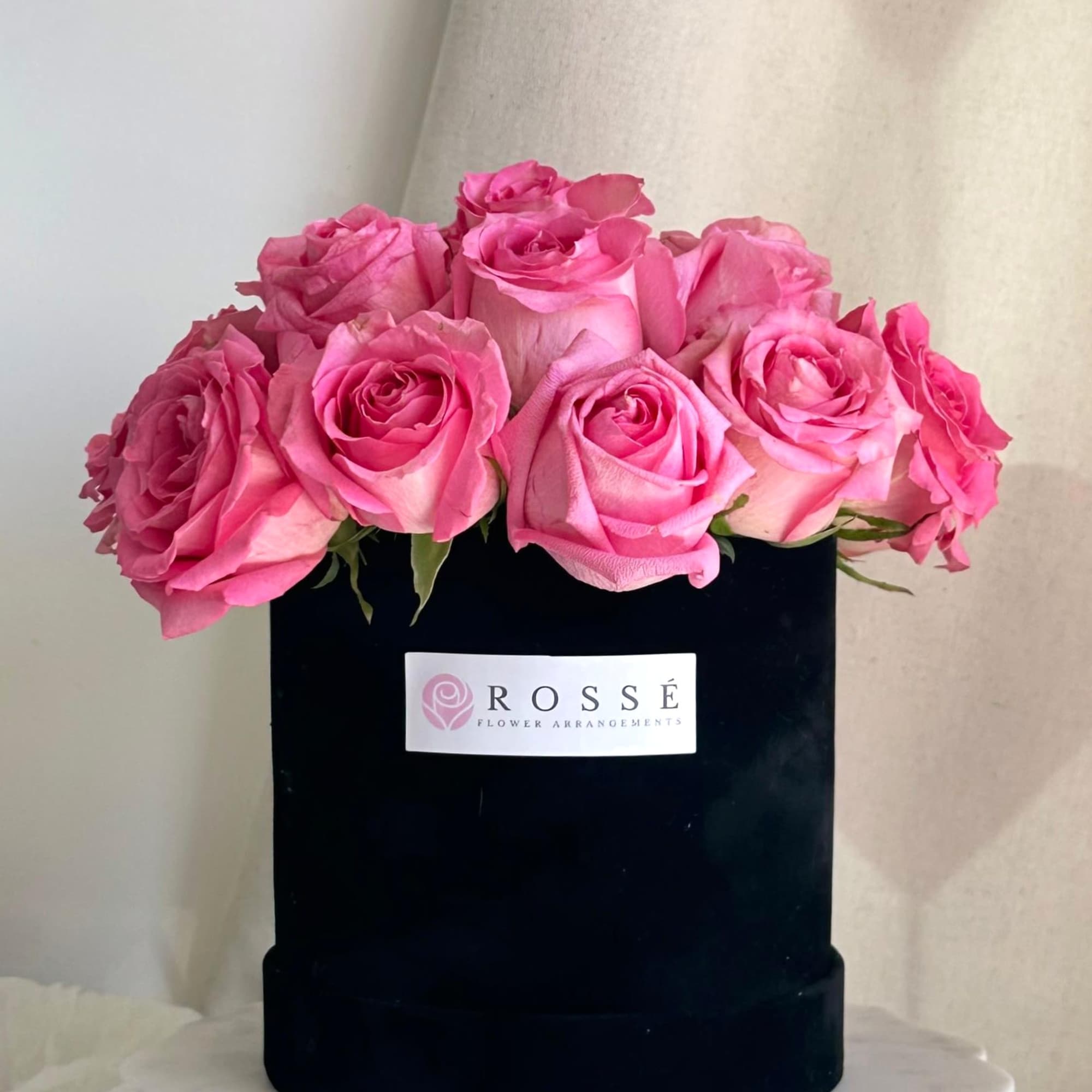 A medium round black velvet box with roses arranged in a dome A medium round black velvet box with roses arranged in a dome