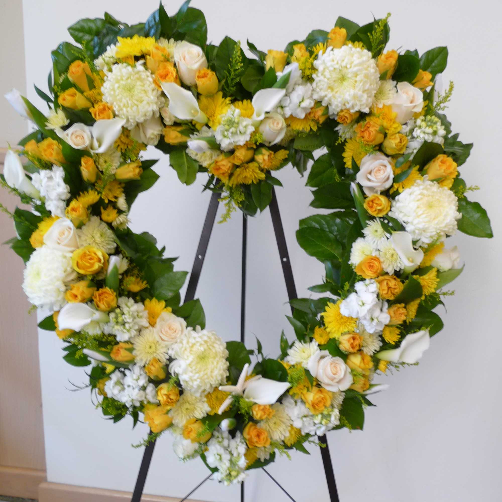 Standing sympathy wreath in the shape of a heart. Made with lush Standing sympathy wreath in the shape of a heart. Made with lush