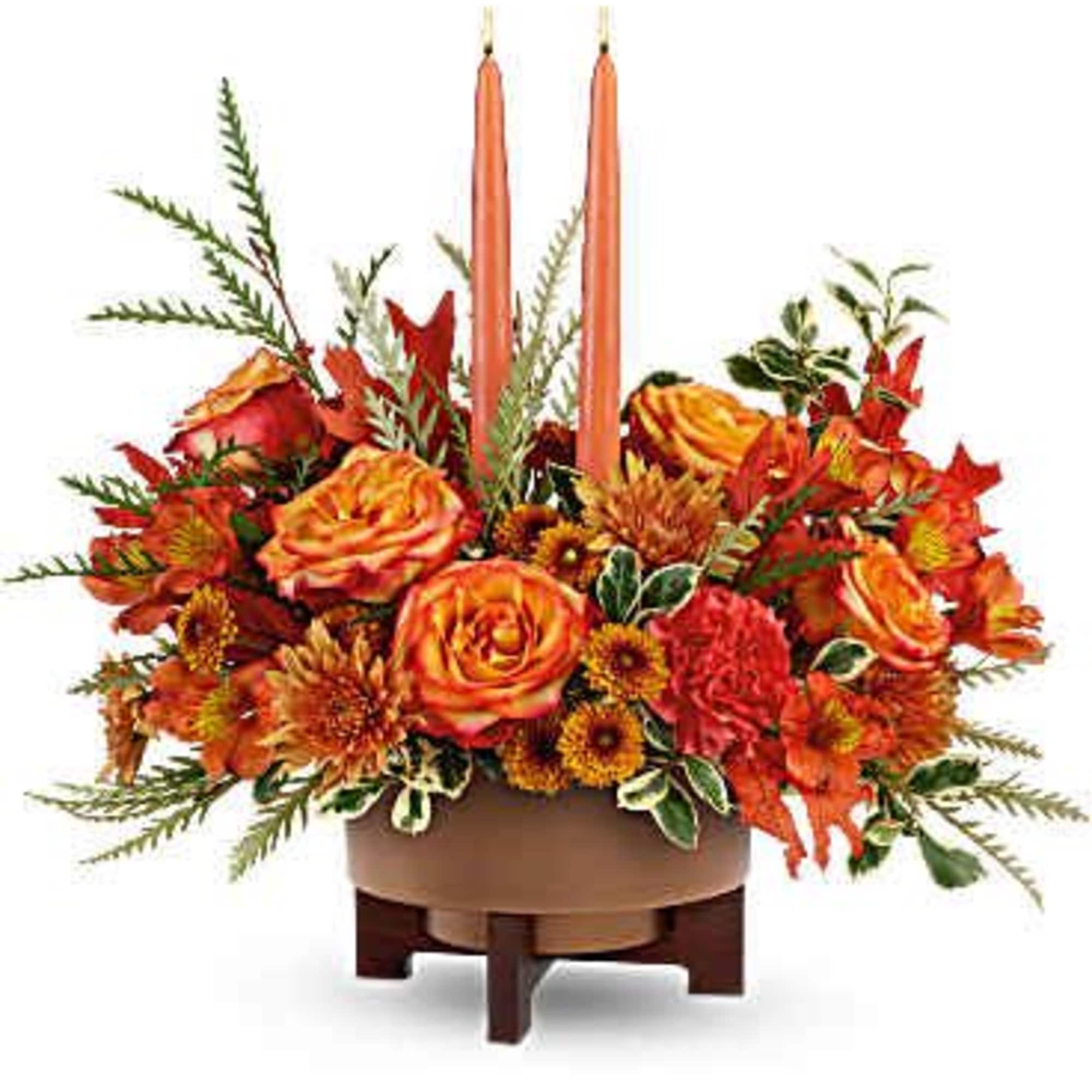 A warm and elegant arrangement of orange roses, carnations, and fall foliage