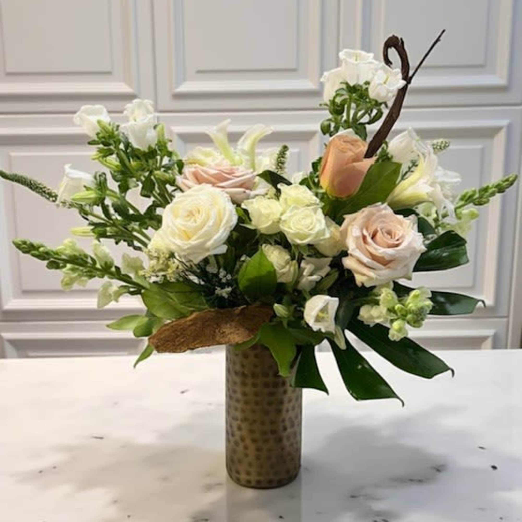An elegant tall arrangement that blends soft blush and dusty tones with