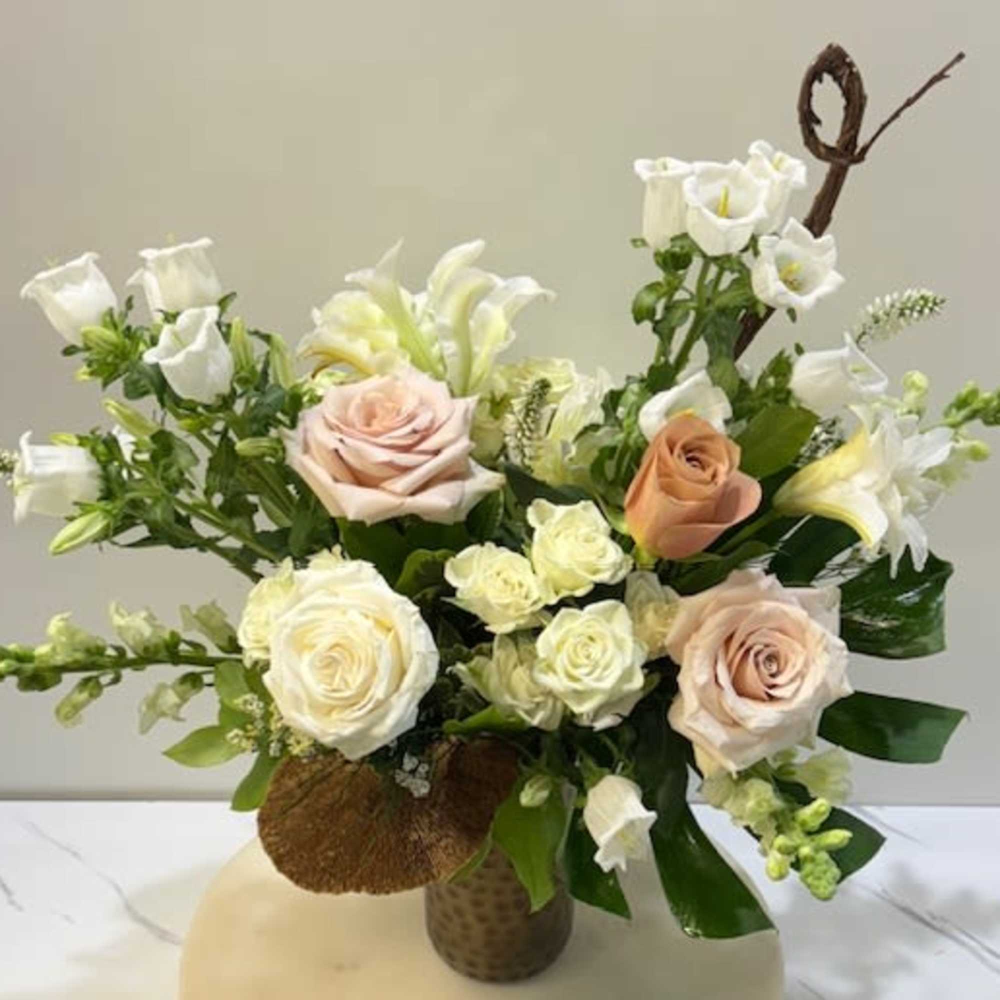 An elegant tall arrangement that blends soft blush and dusty tones with