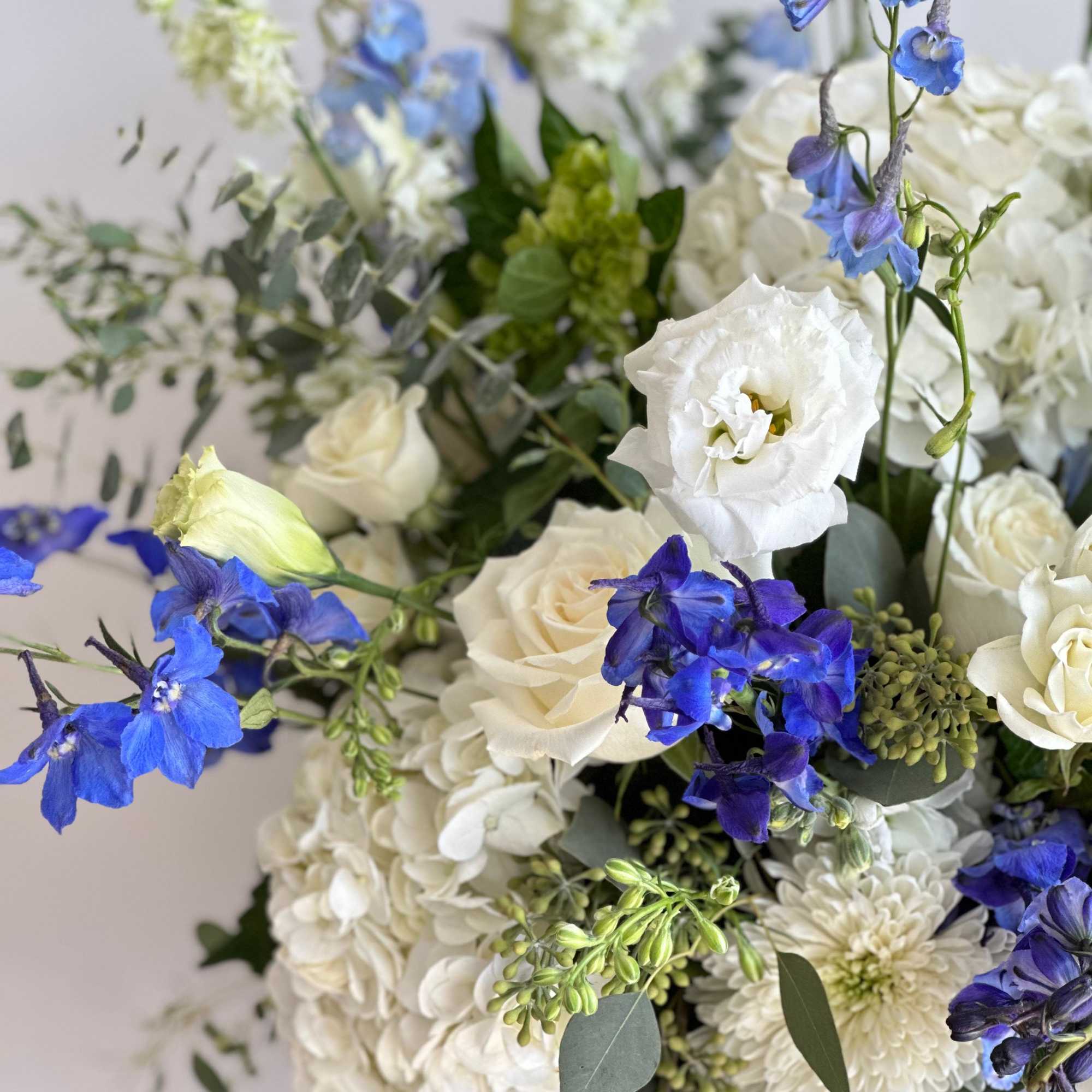 A tall blue velvet cylinder Box filled with a mix of blue