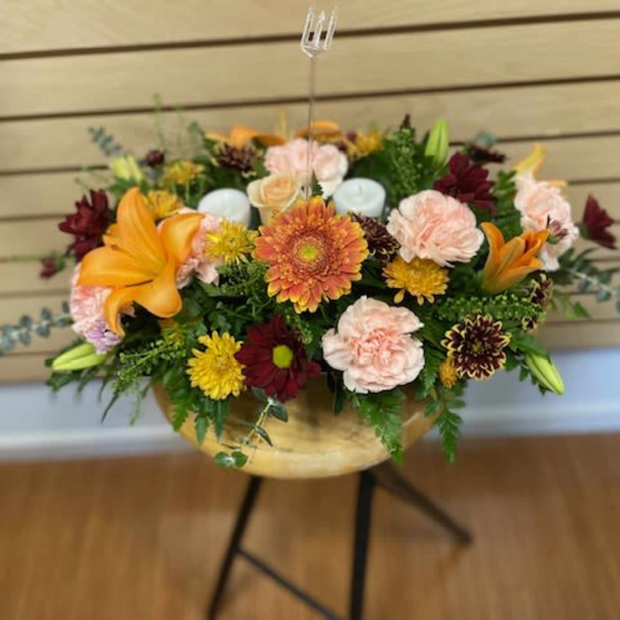 Fall centerpiece with mixed flowers and candles. The arrangement contains orange lilies Fall centerpiece with mixed flowers and candles. The arrangement contains orange lilies