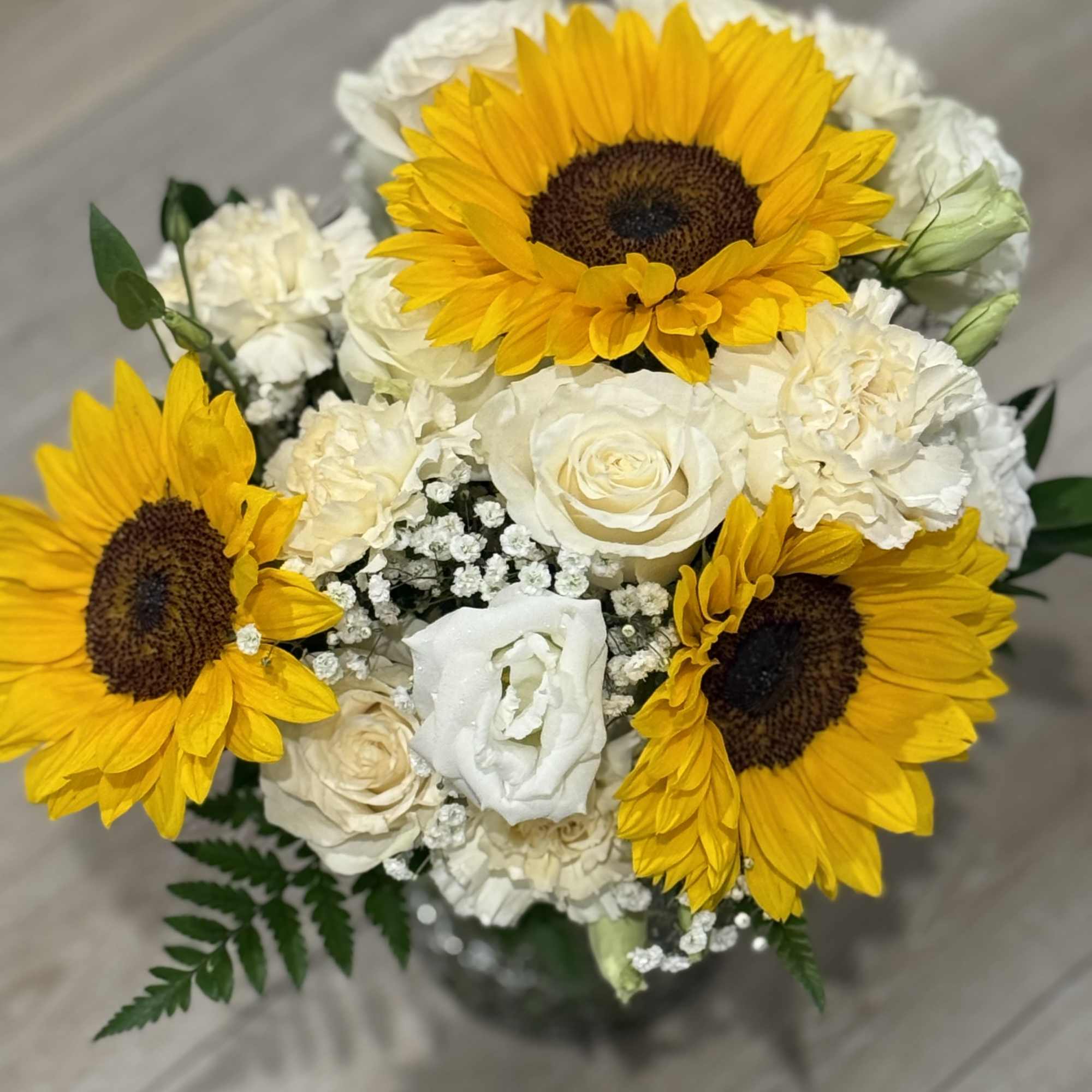 Mix flower arrangement for any occasion 

Sunflowers 
White Roses 
Cream carnations 
White