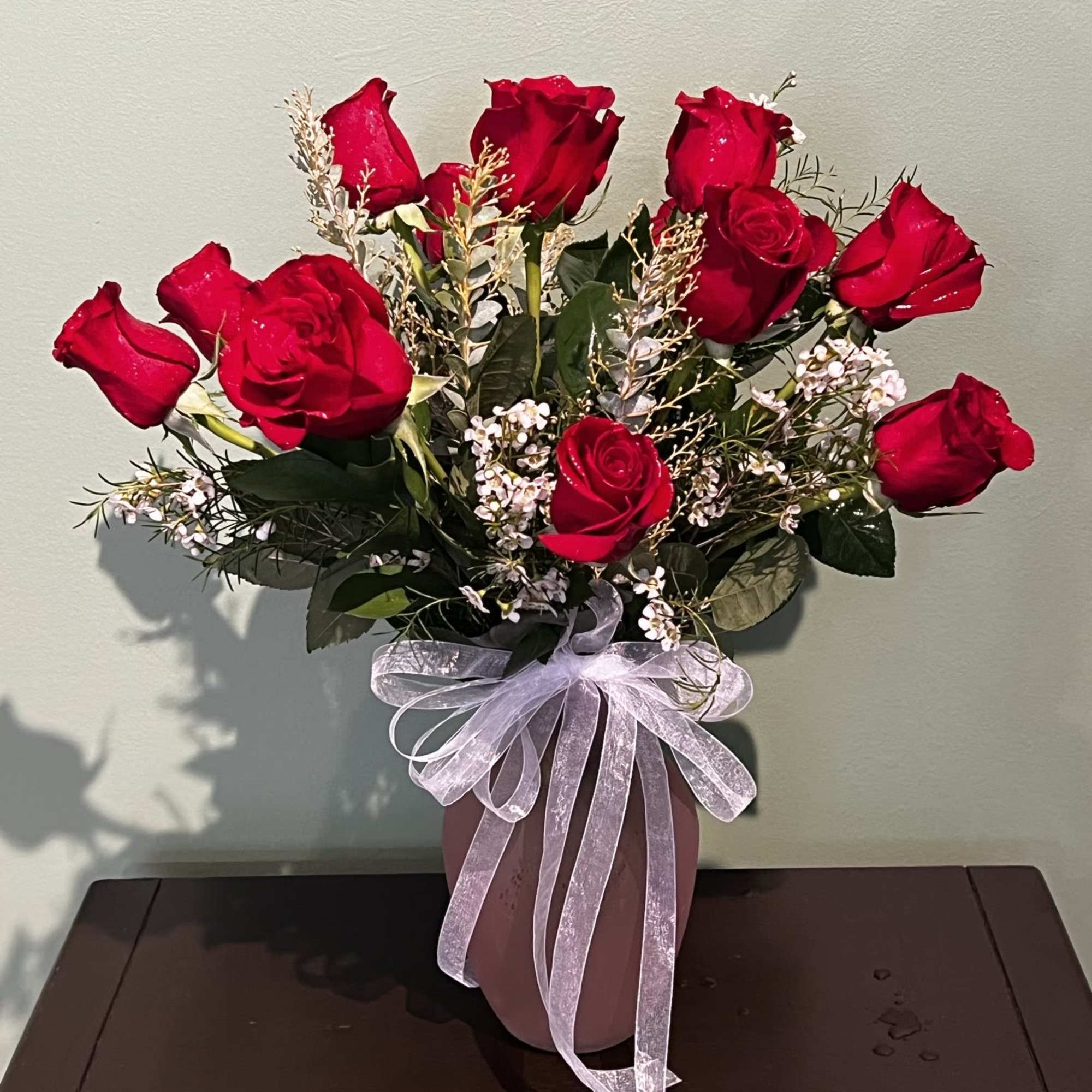 One dozen roses in a vase.

*Be aware that due to a global