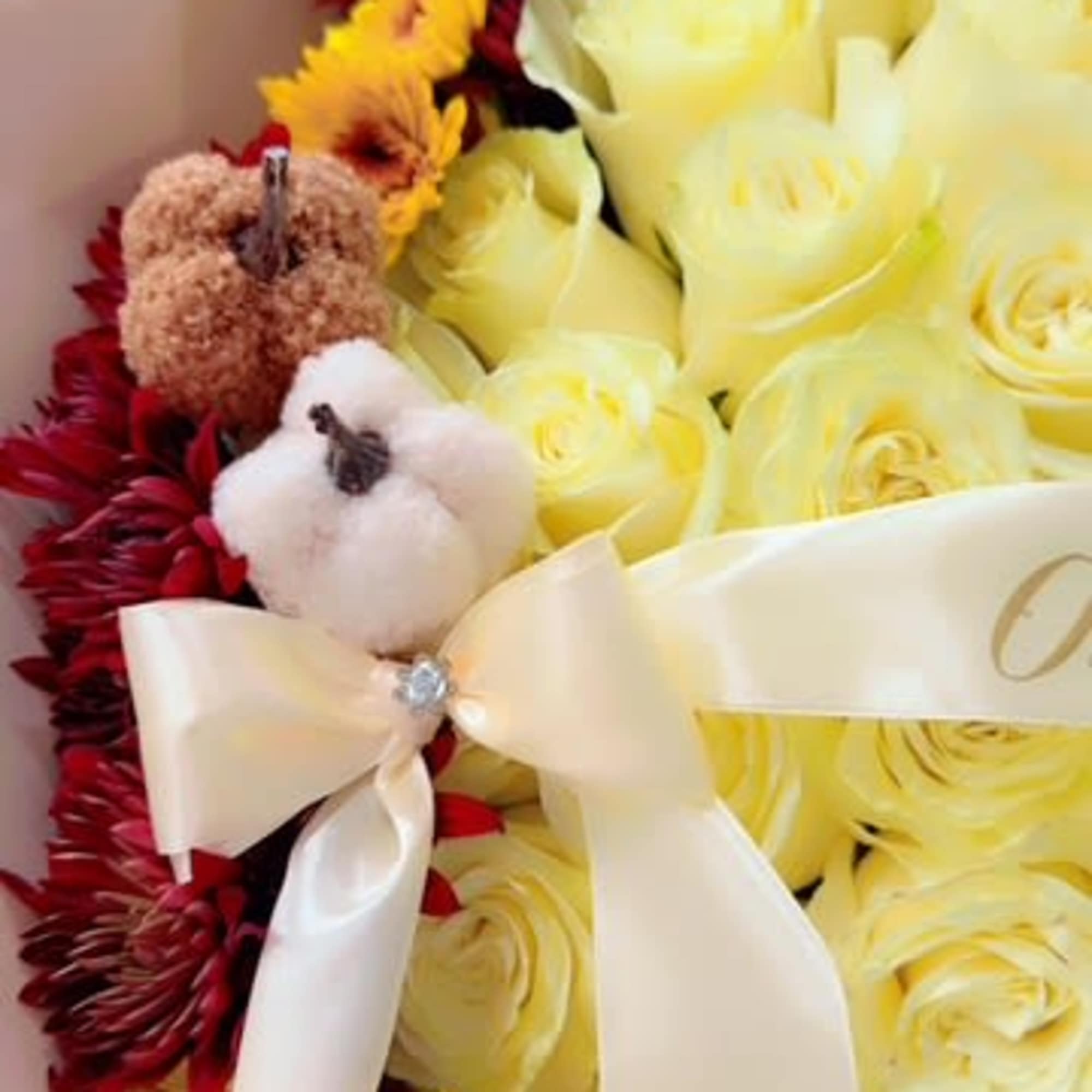 An elegant arrangement of cream-colored roses surrounded by a crown of deep An elegant arrangement of cream-colored roses surrounded by a crown of deep
