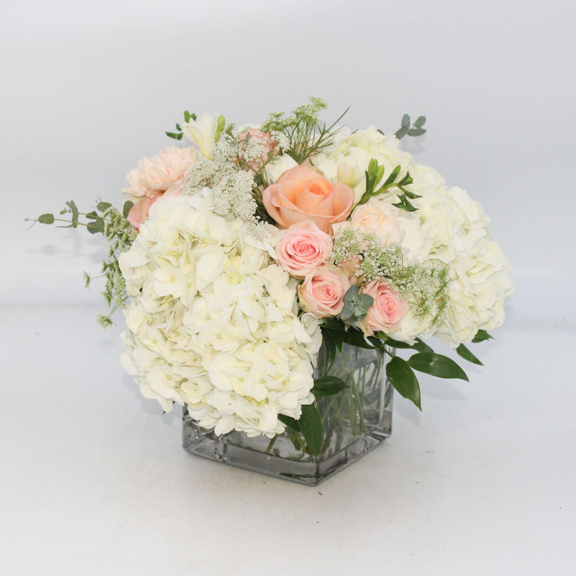 Piazza features White Hydrangea, Peach Roses, Blush Pink Spray Roses, White Freesia