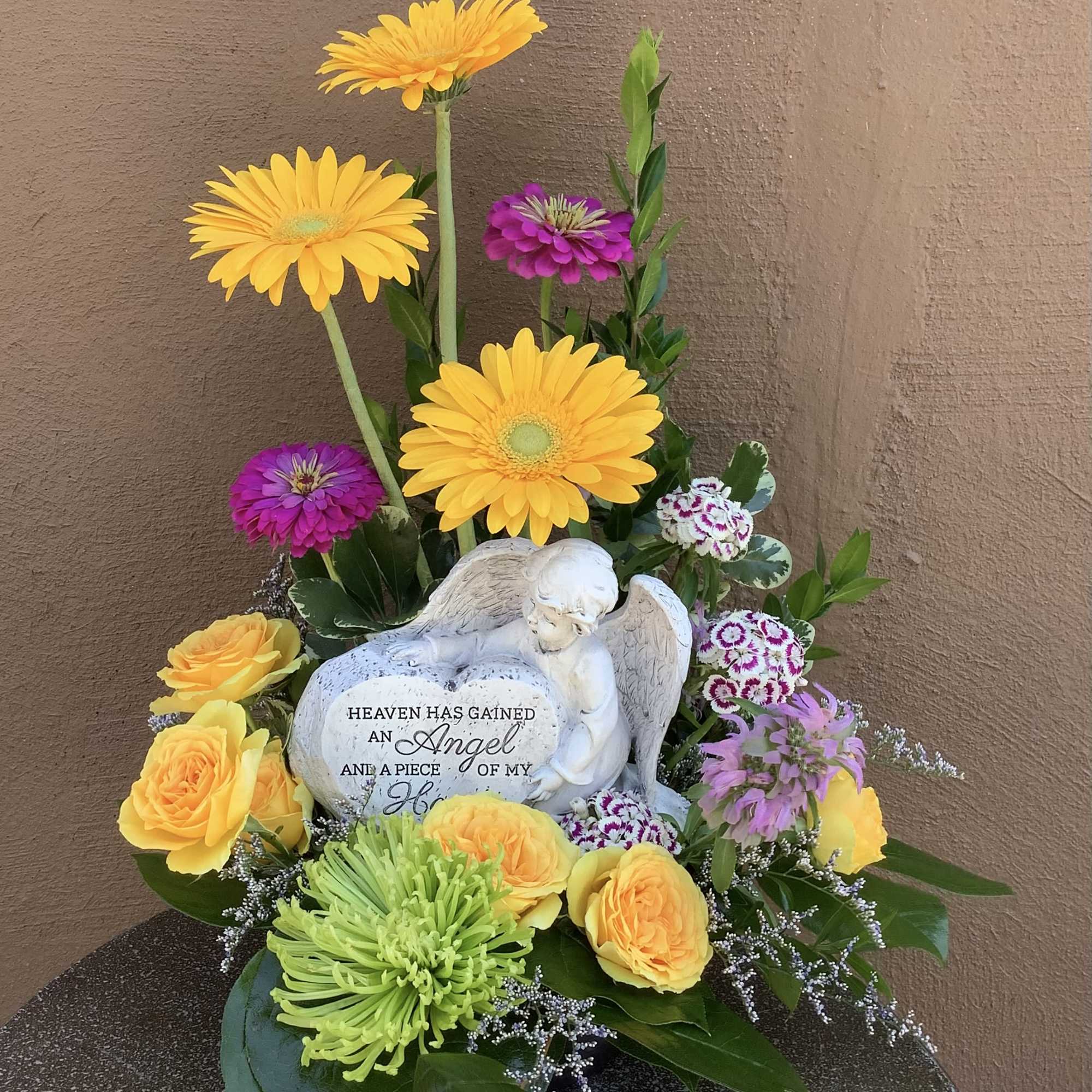 An angel with a heart that stands approximately 6 inches tall With