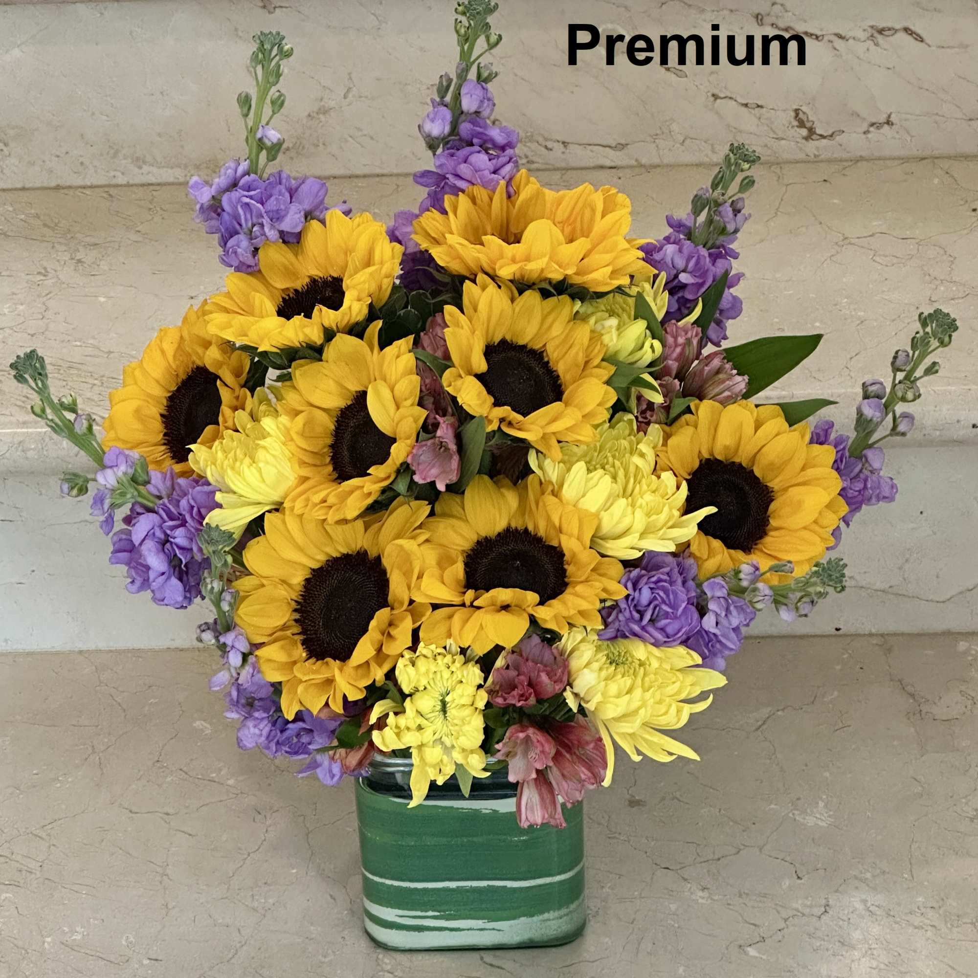 A cheerful mix of sunflowers, burgundy snapdragons, yellow mums, and other seasonal A cheerful mix of sunflowers, burgundy snapdragons, yellow mums, and other seasonal
