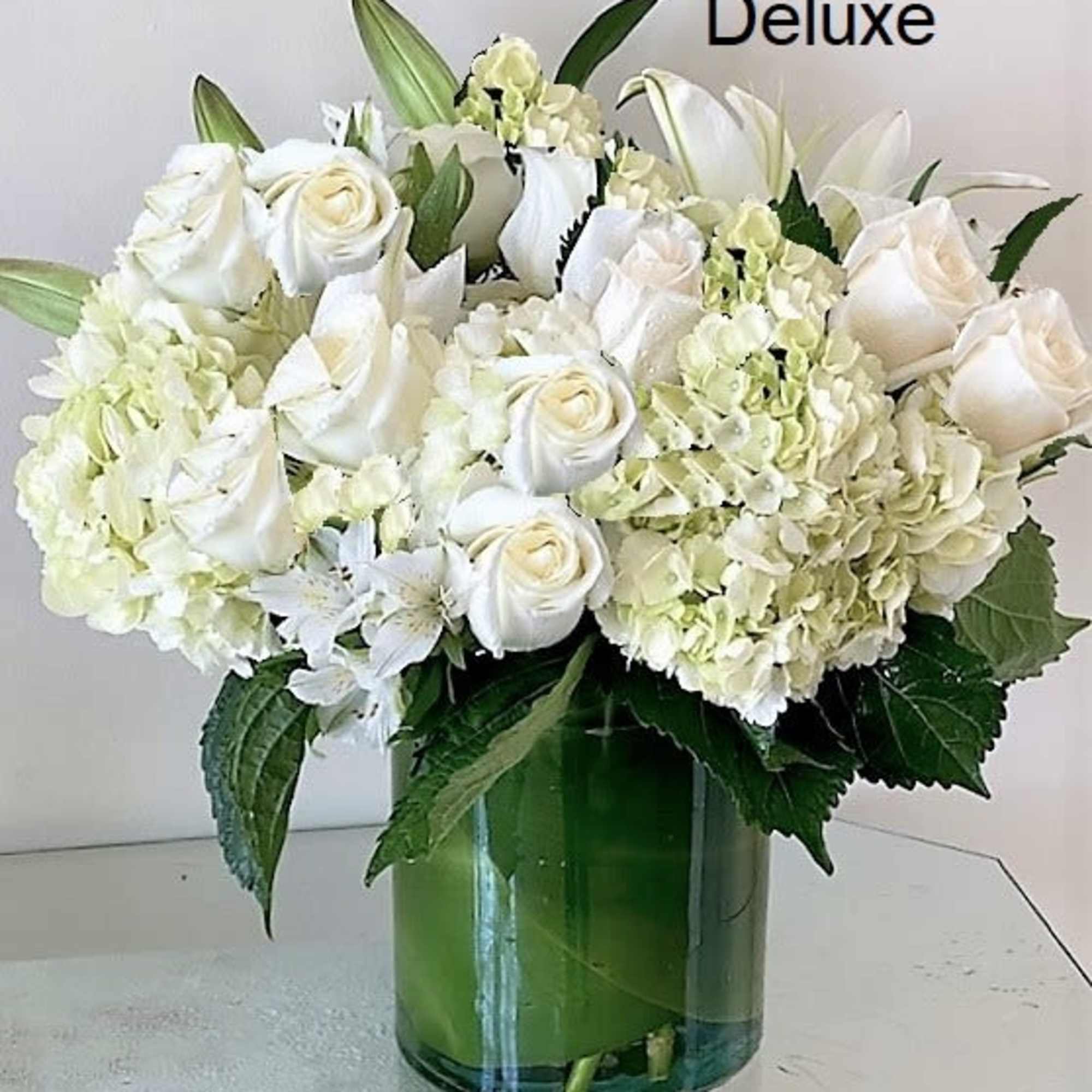 White flowers as shown arranged in a vase. Photos shown are Standard White flowers as shown arranged in a vase. Photos shown are Standard