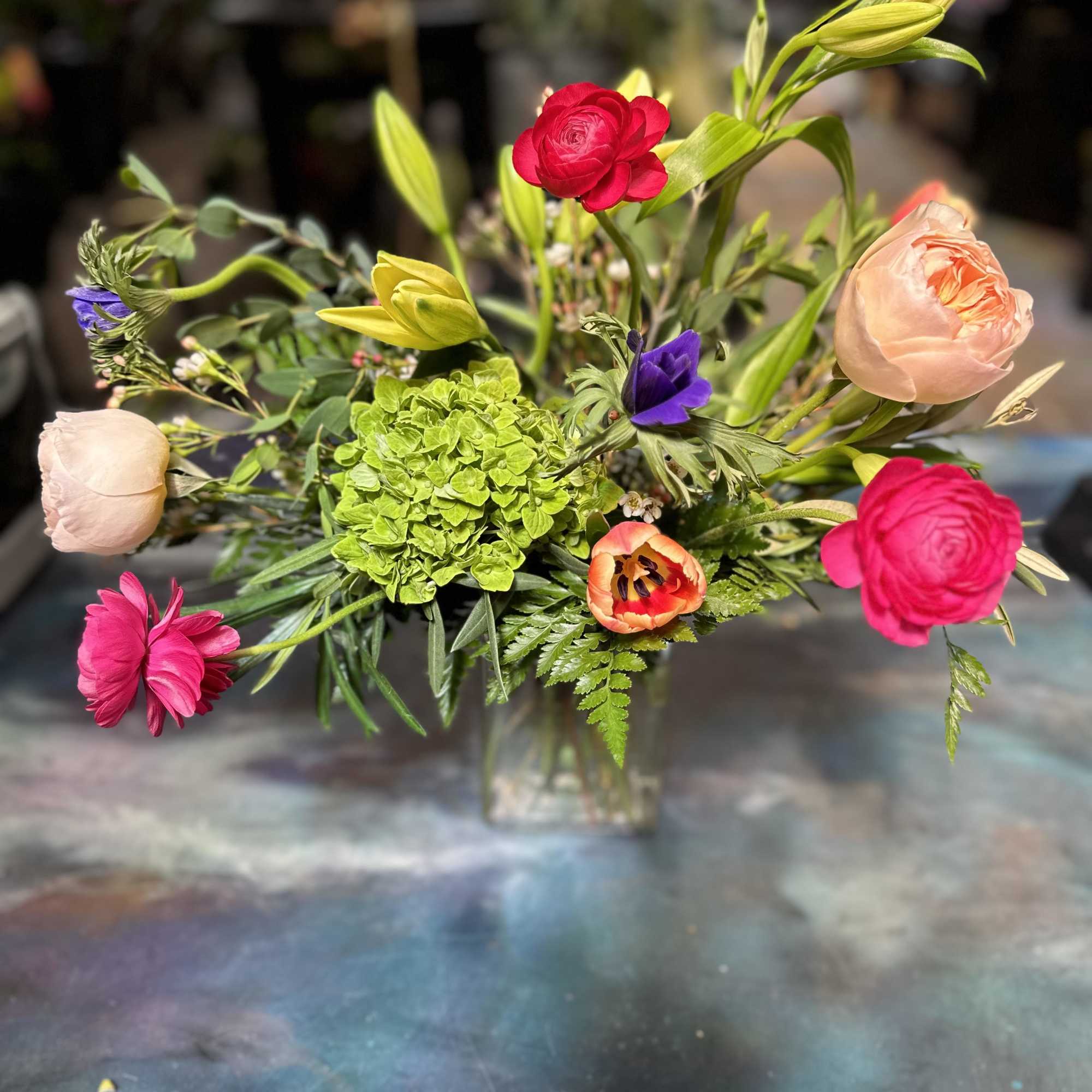 Designed using peach Juliet garden roses, yellow asiatic liles, hot pink raspberry