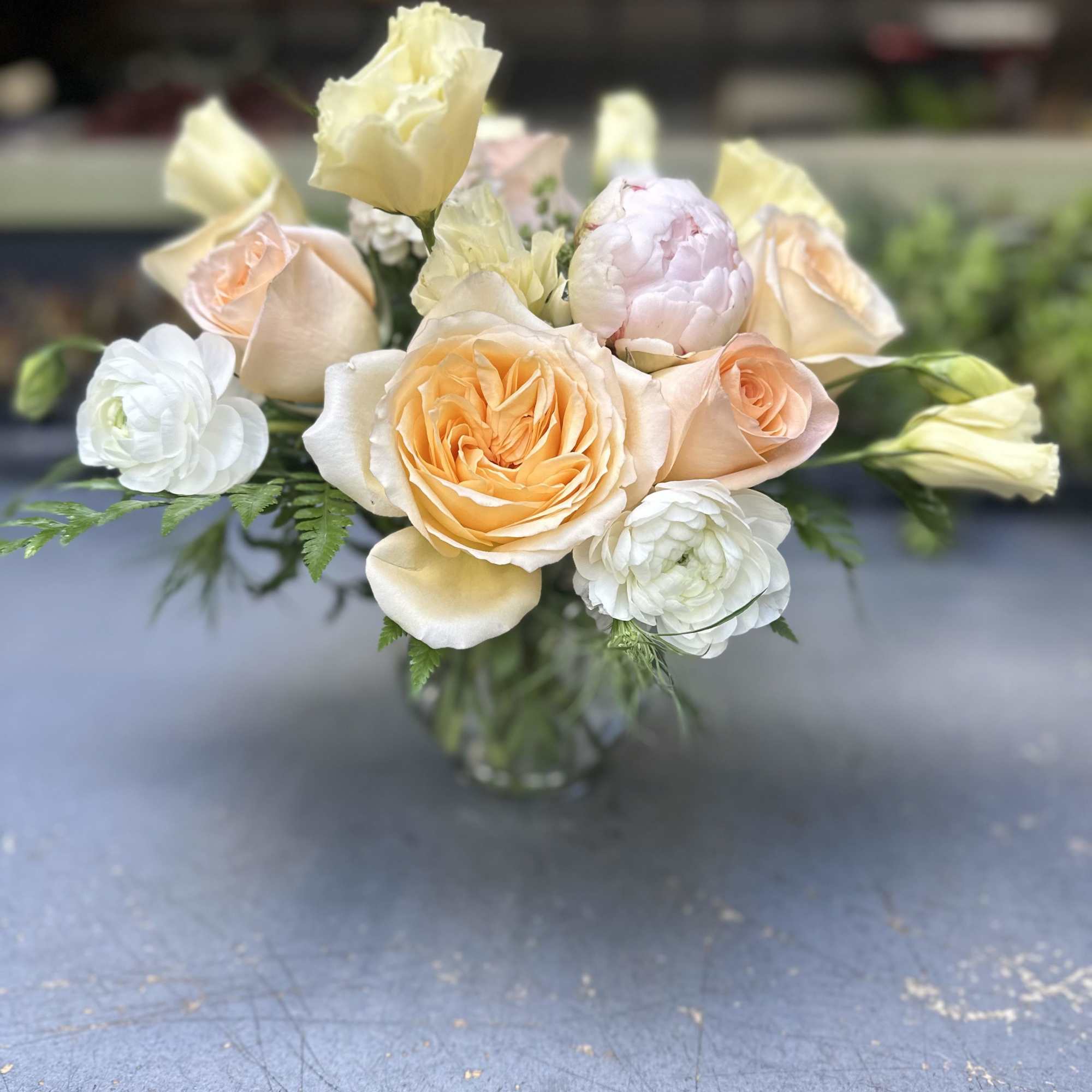 A lovely arrangement designed using peachy garden roses, peach standard roses, pale