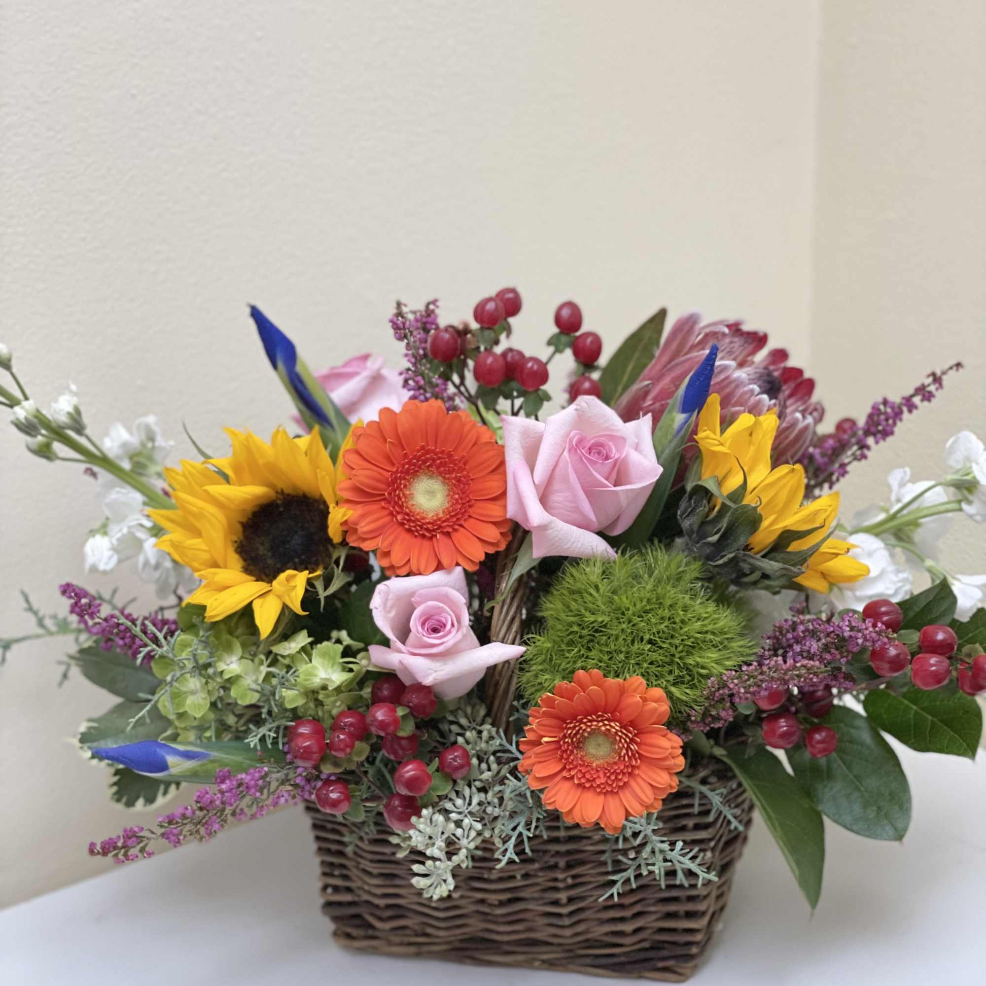 A basket brimming with seasonal blooms and greens.