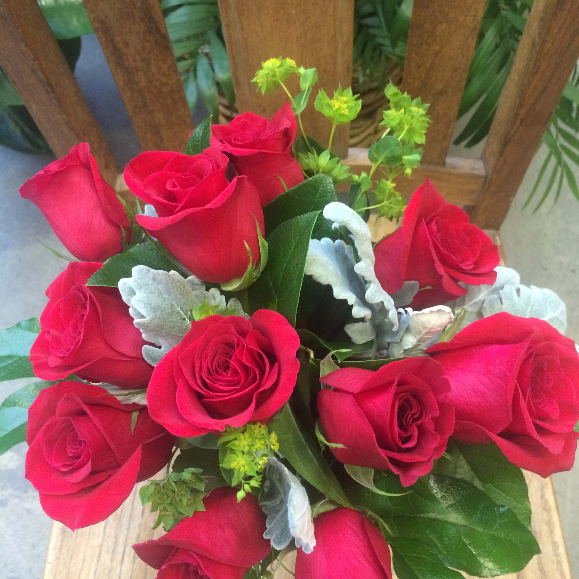 A dozen beautiful short stem roses in a clear glass vase with