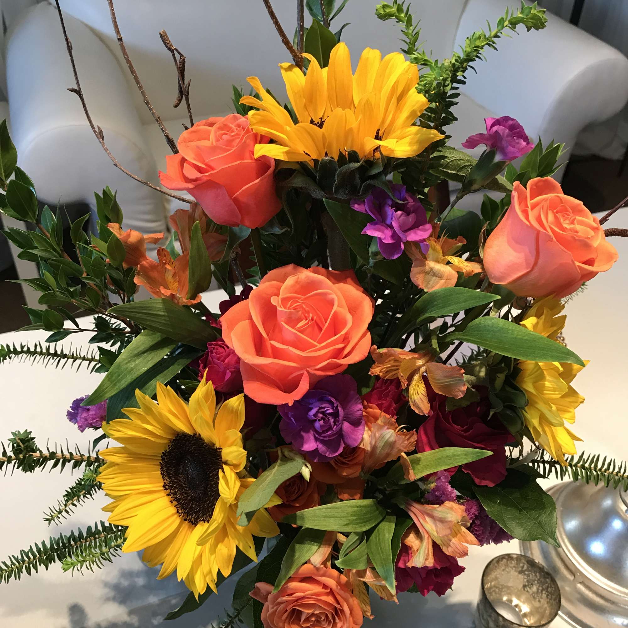 A beautiful tall slender arrangement is full of bright colors. 
This arrangement