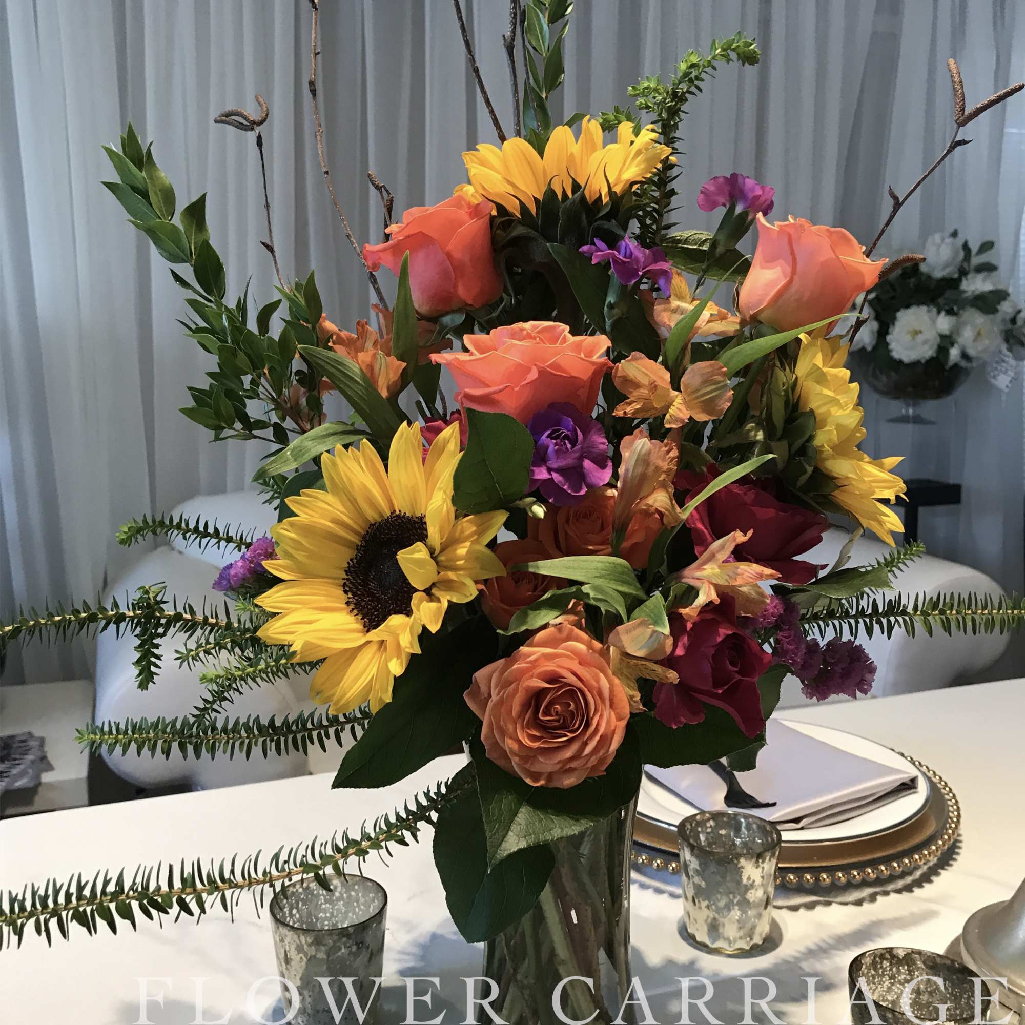 A beautiful tall slender arrangement is full of bright colors. 
This arrangement