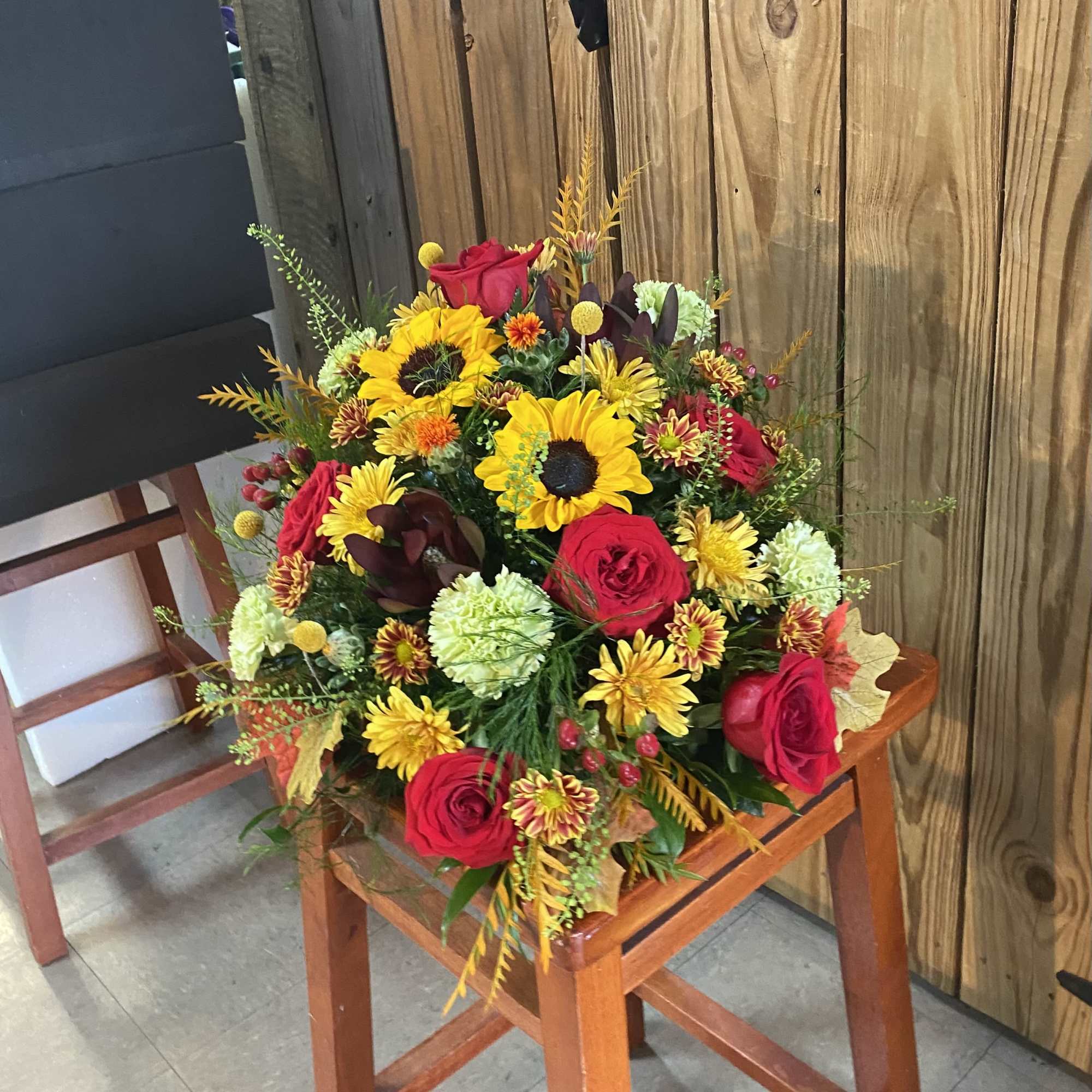 Beautiful fall mix arranged in wicker cornucopia. Great low style design for