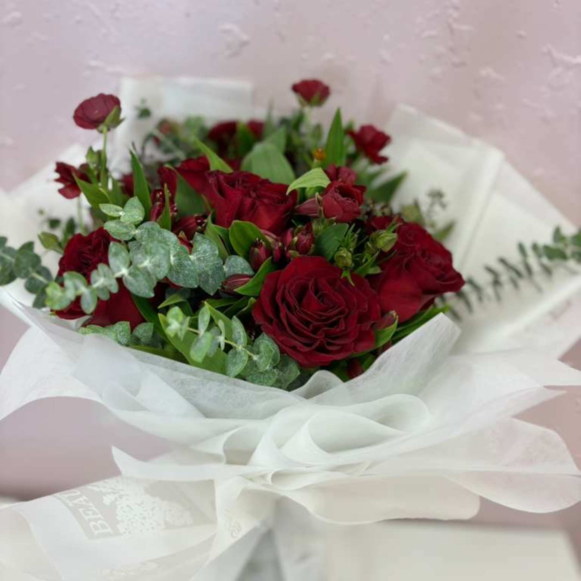 Beautiful bouquet of 12 Ecuadorian red roses filled with fresh foliage of