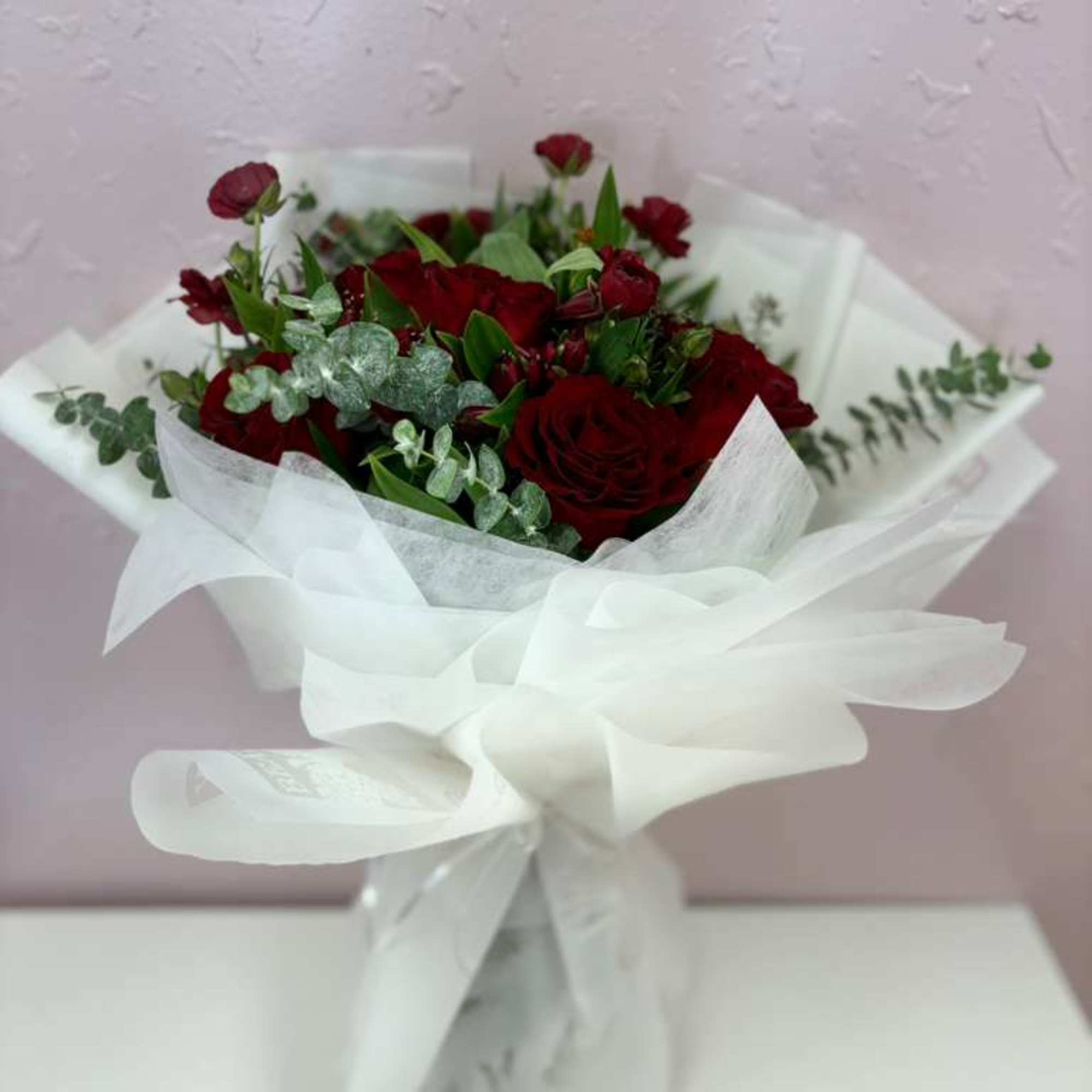 Beautiful bouquet of 12 Ecuadorian red roses filled with fresh foliage of