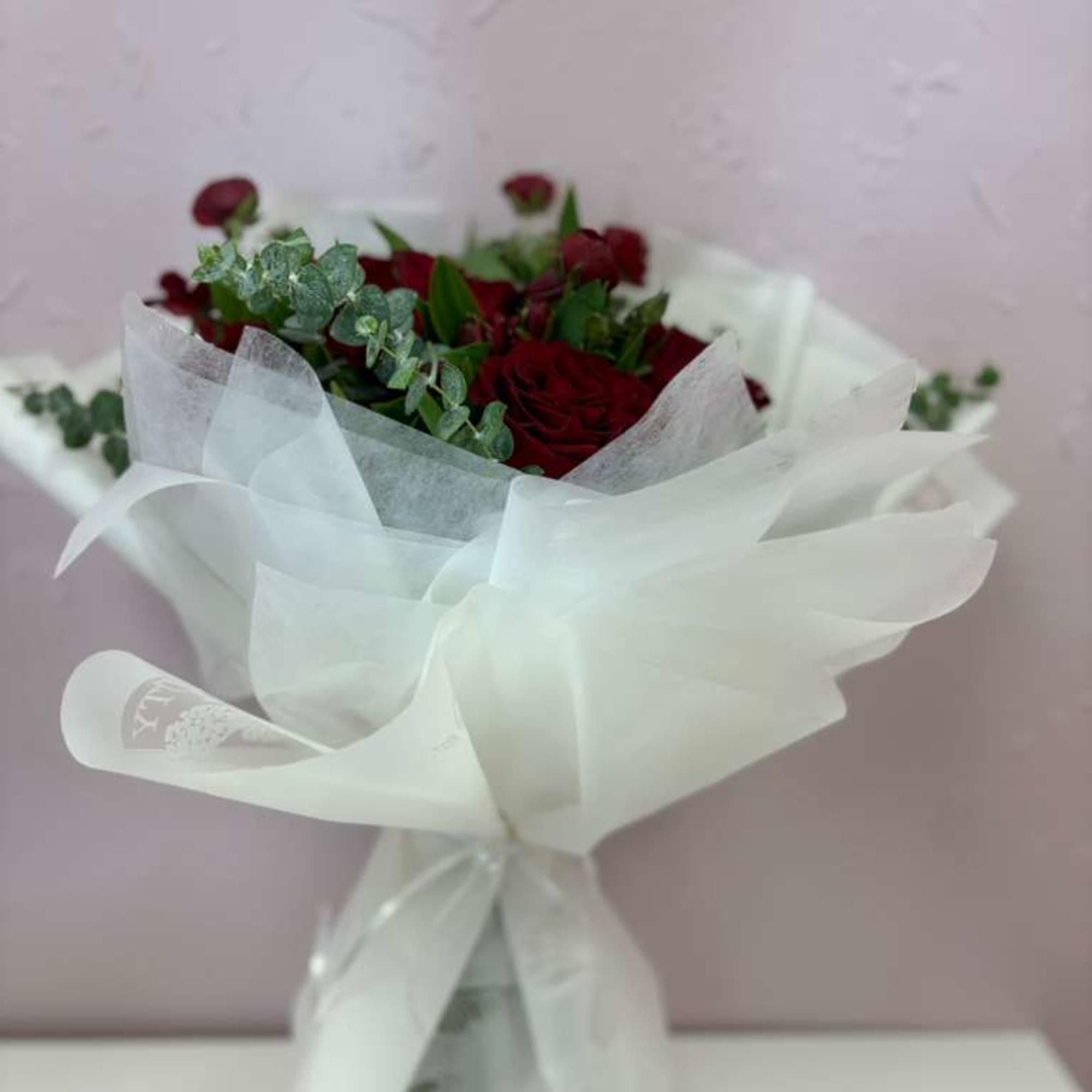 Beautiful bouquet of 12 Ecuadorian red roses filled with fresh foliage of