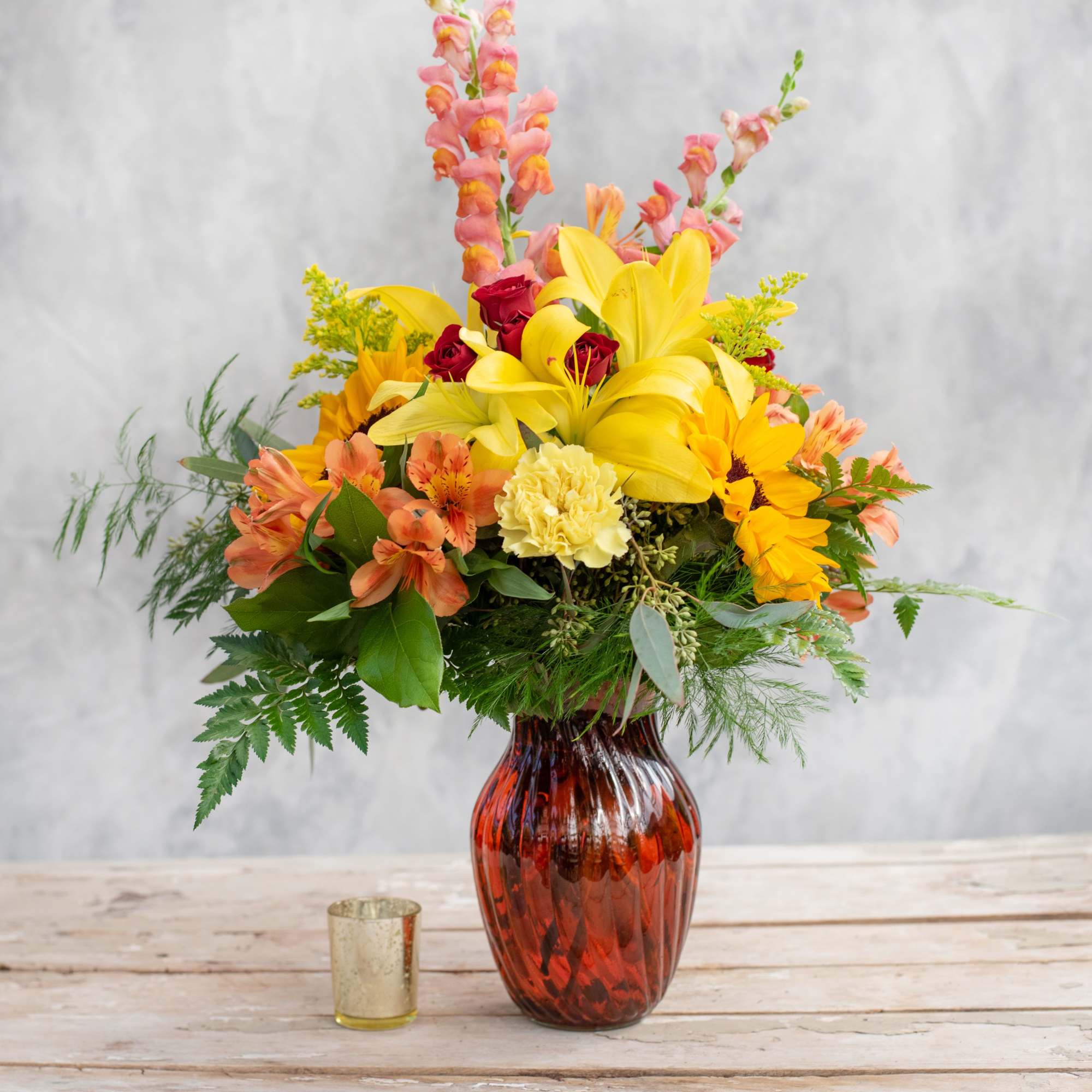 Bright yellow sunflowers, red spray roses, snap dragons and lilies among some Bright yellow sunflowers, red spray roses, snap dragons and lilies among some