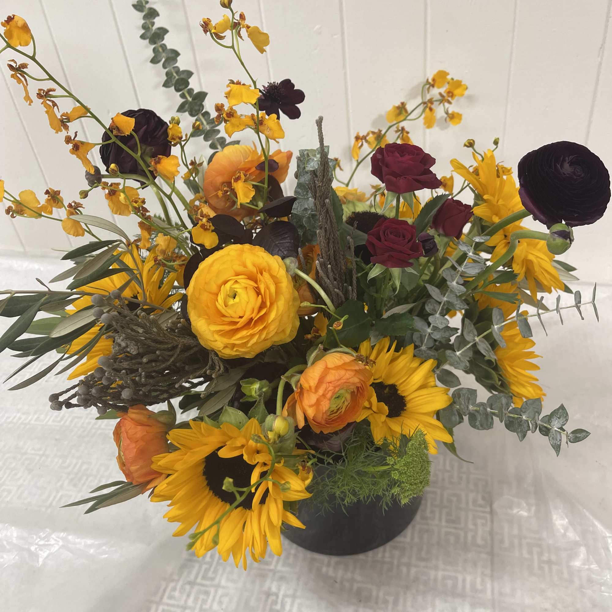 Floral arrangement in primarily yellow and orange hues designed in the spirit