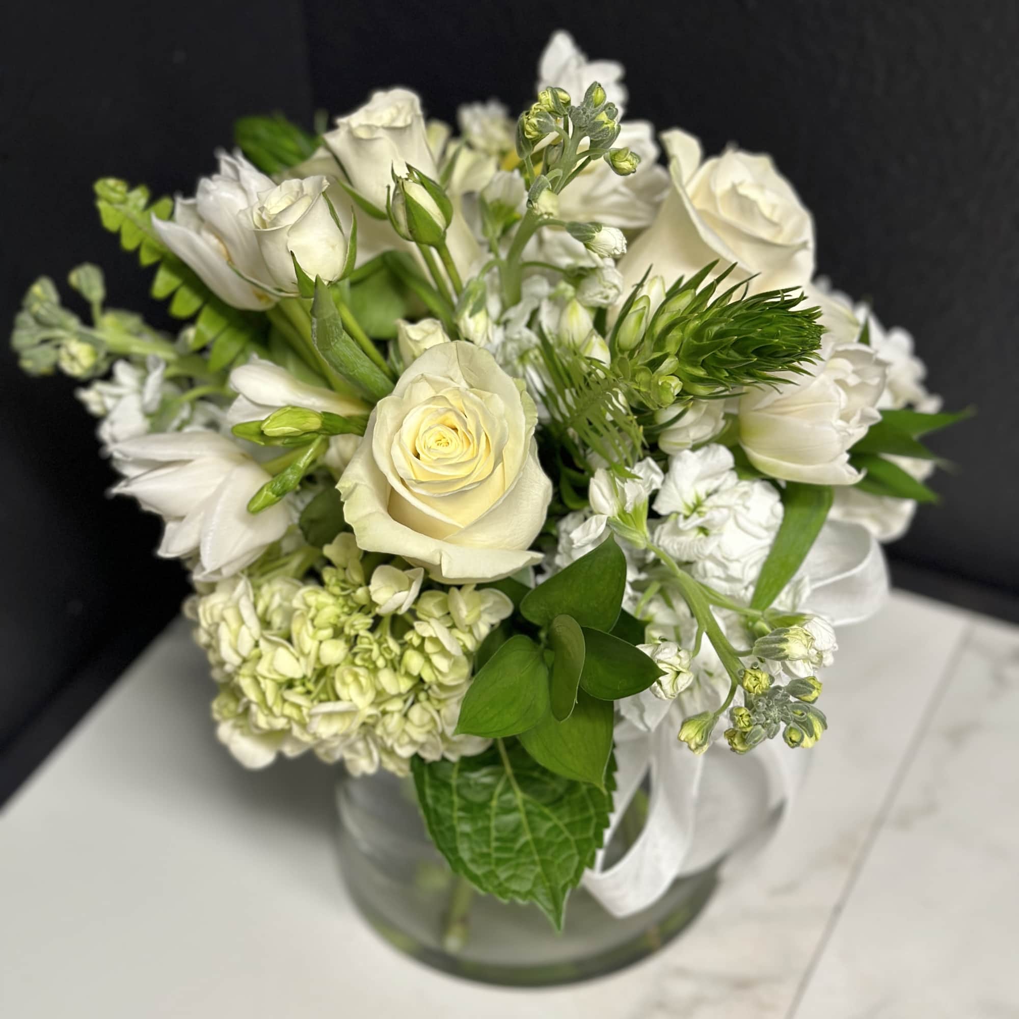An elegant seasonal garden mix in creamy whites and greens. Arranged low
