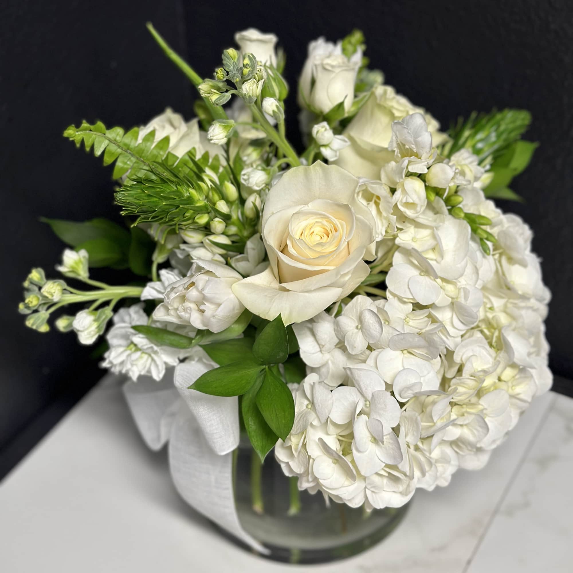 An elegant seasonal garden mix in creamy whites and greens. Arranged low