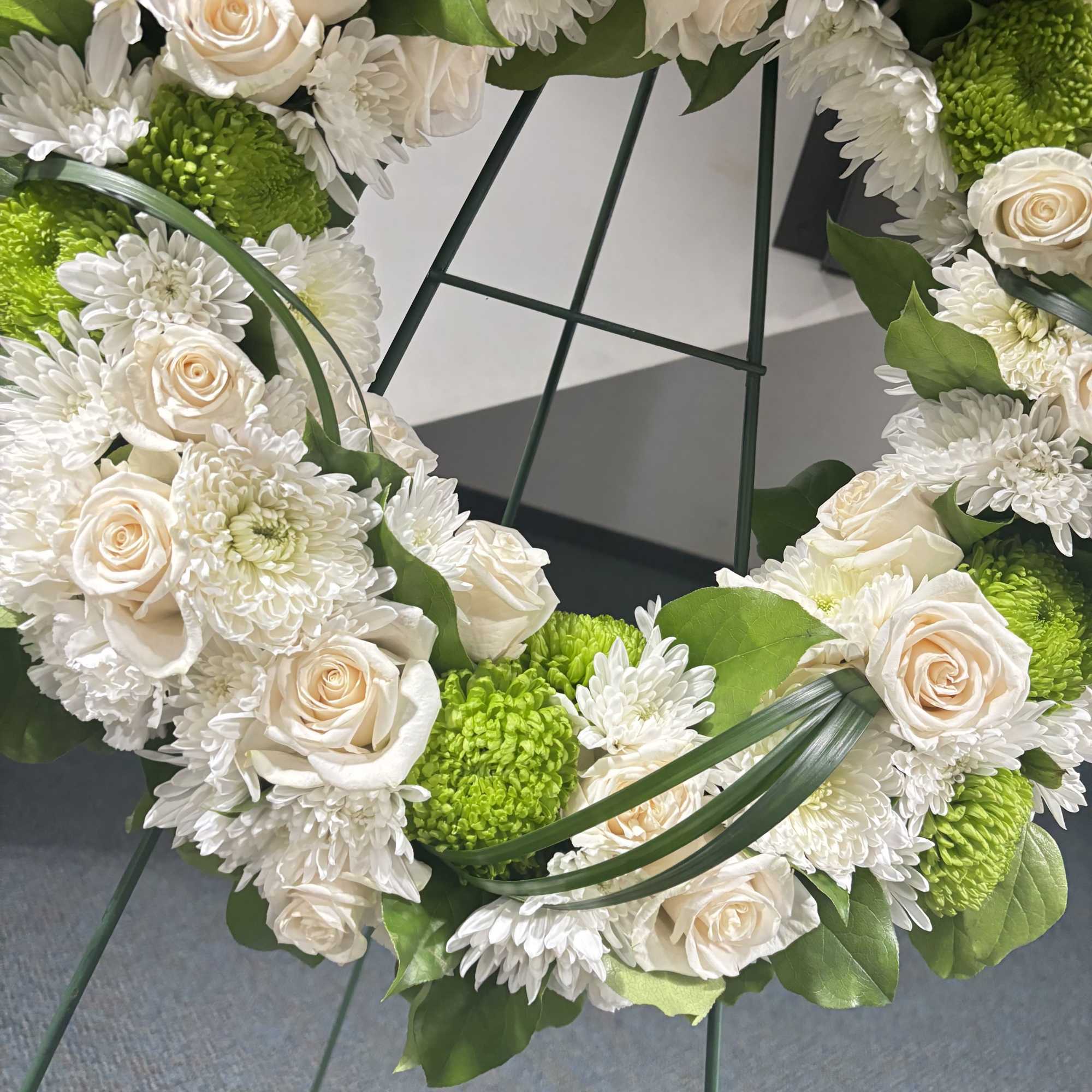 Express your heartfelt condolences with our White &amp; Green Sympathy Wreath, a