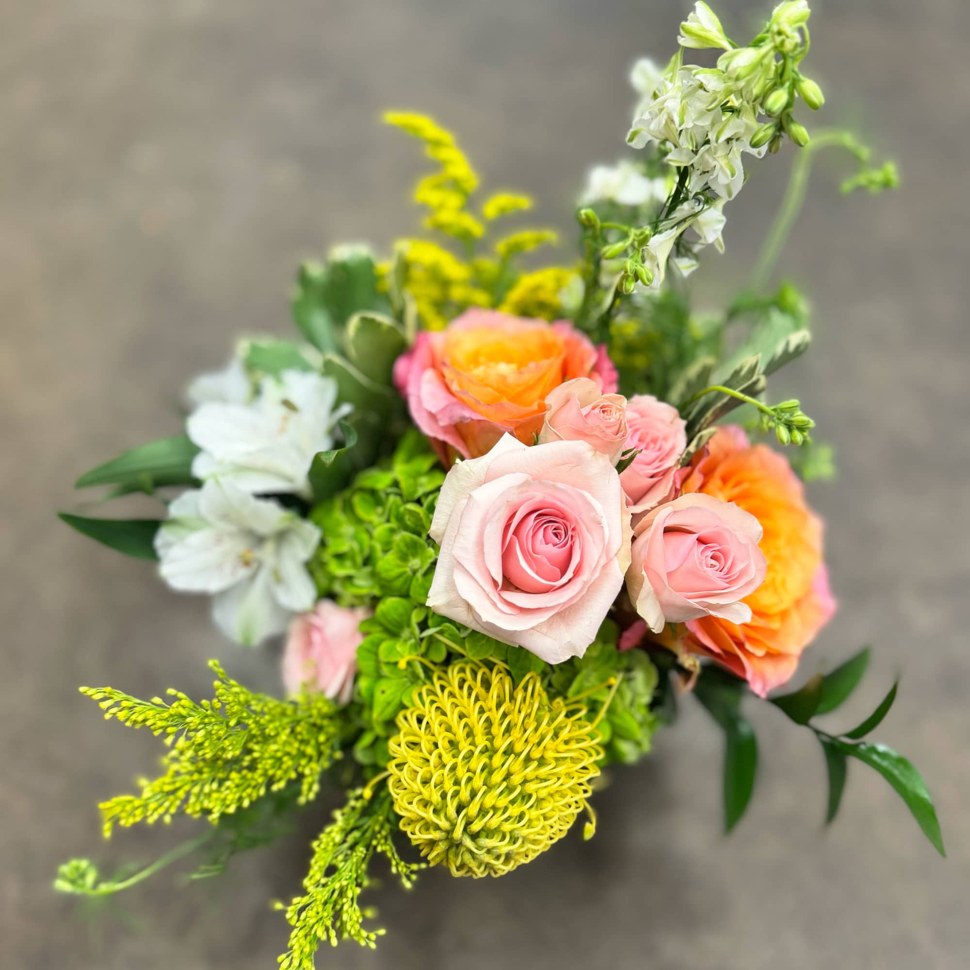 Bright and cheerful, this garden-style design pairs orangey/peach roses, pink spray roses Bright and cheerful, this garden-style design pairs orangey/peach roses, pink spray roses