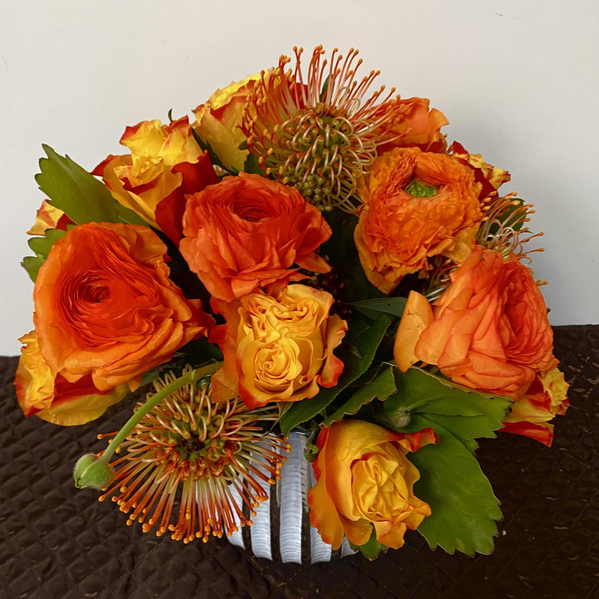 in a very nice vase with a orange roses and pink cushions