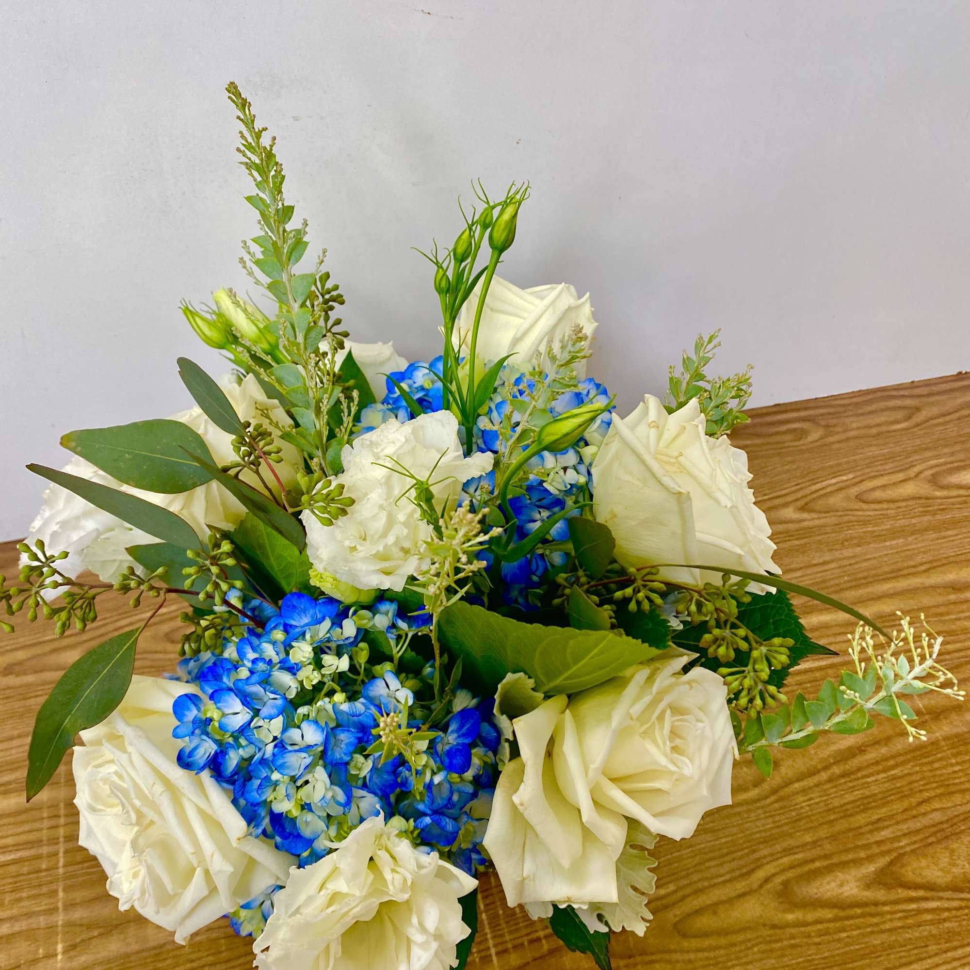 in a glass vase hydrangeas, roses, orchids