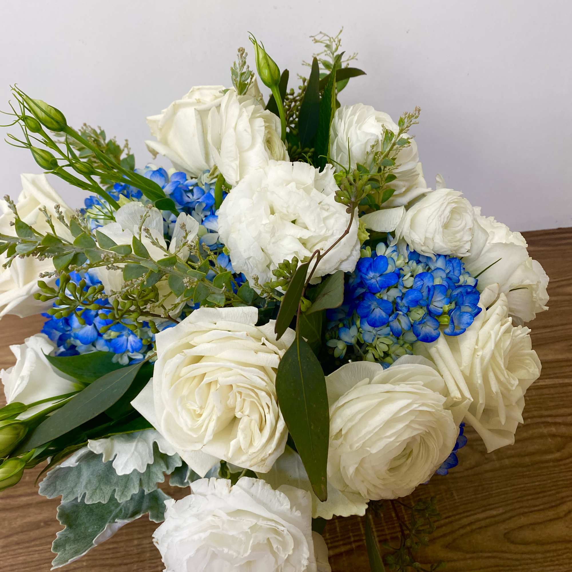 in a glass vase hydrangeas, roses, orchids