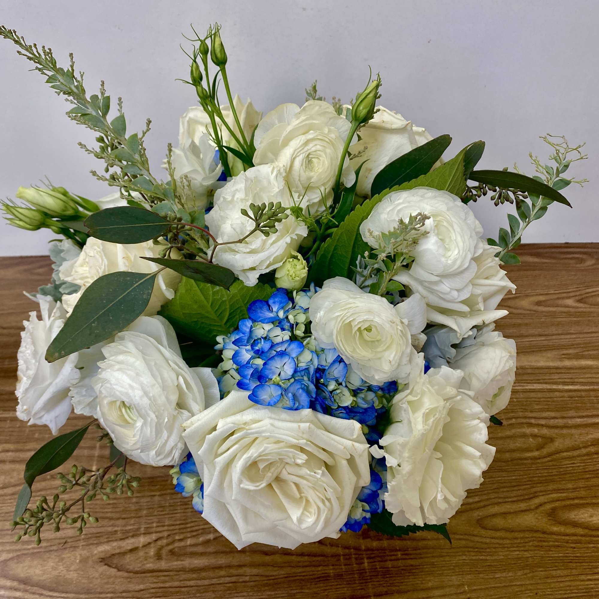 in a glass vase hydrangeas, roses, orchids