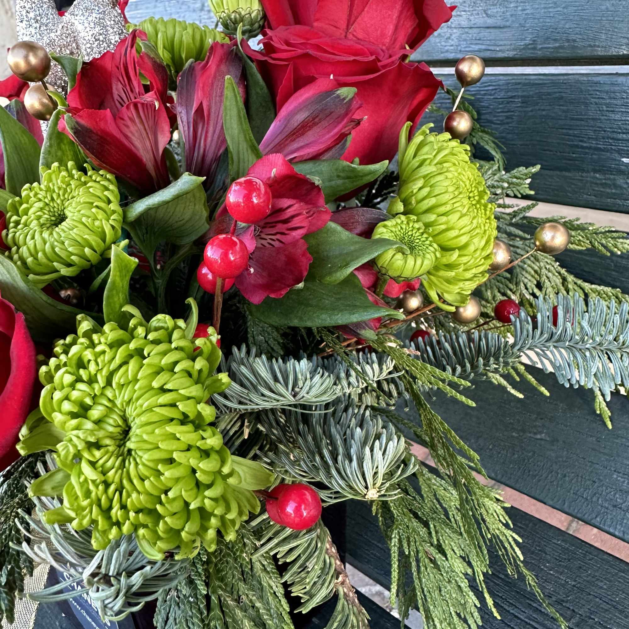 Beautiful seasonal design made with fresh Christmas greens and roses. Very decorative