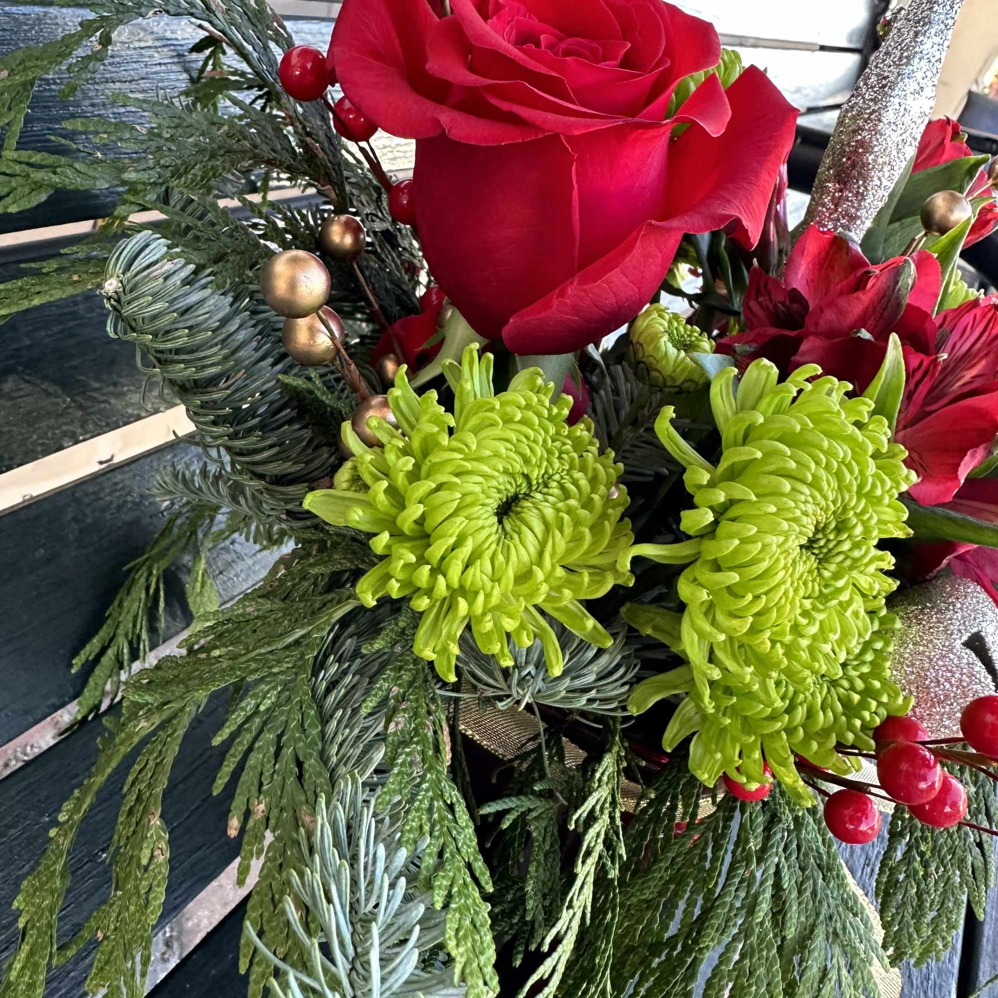 Beautiful seasonal design made with fresh Christmas greens and roses. Very decorative