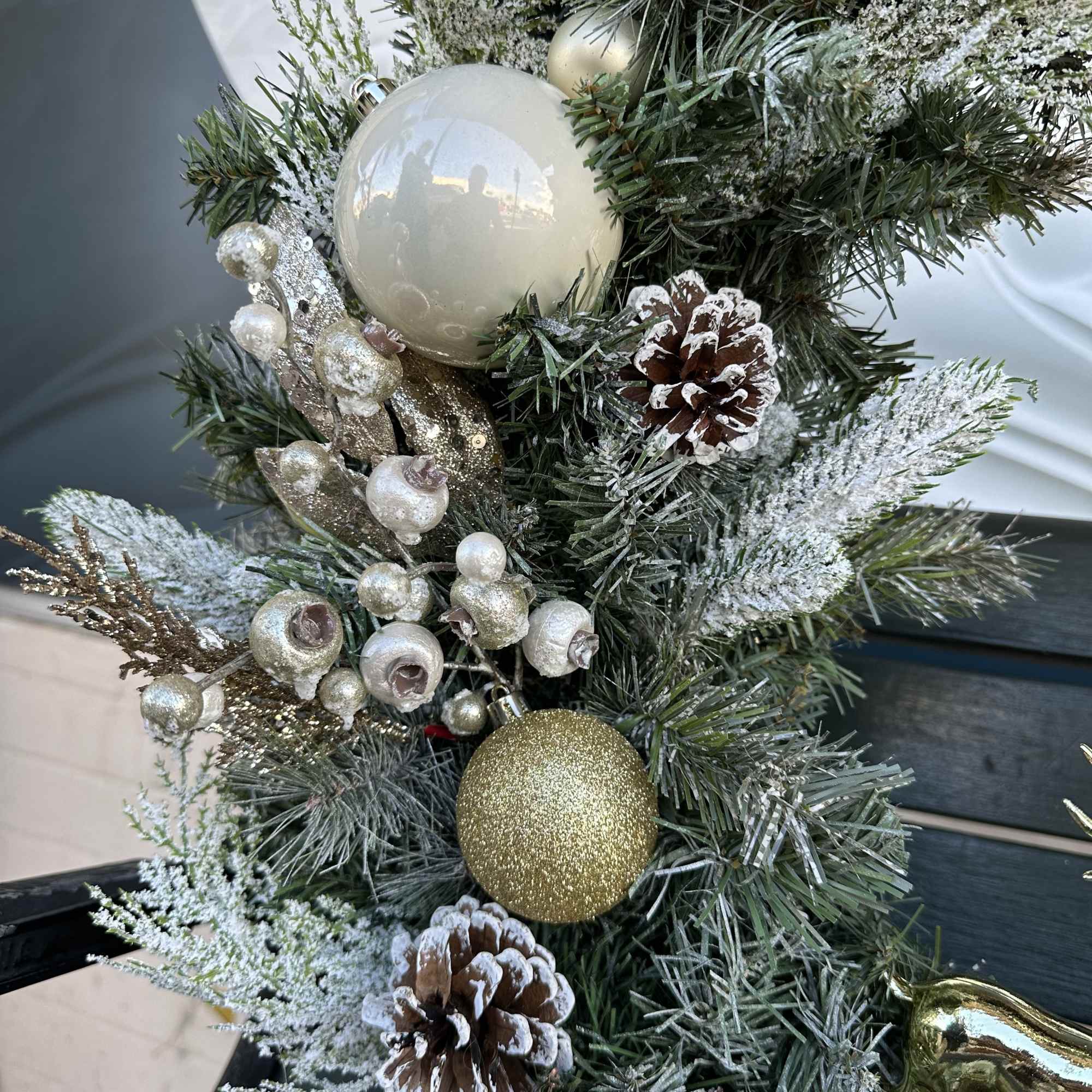 Artificial wreath with ornaments, decorations and a ribbon