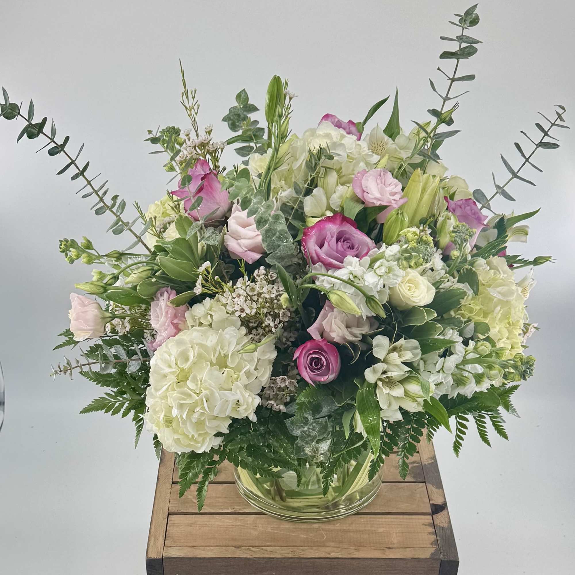 Experience the perfect harmony of roses, hydrangea, white stock, and pink lisianthus