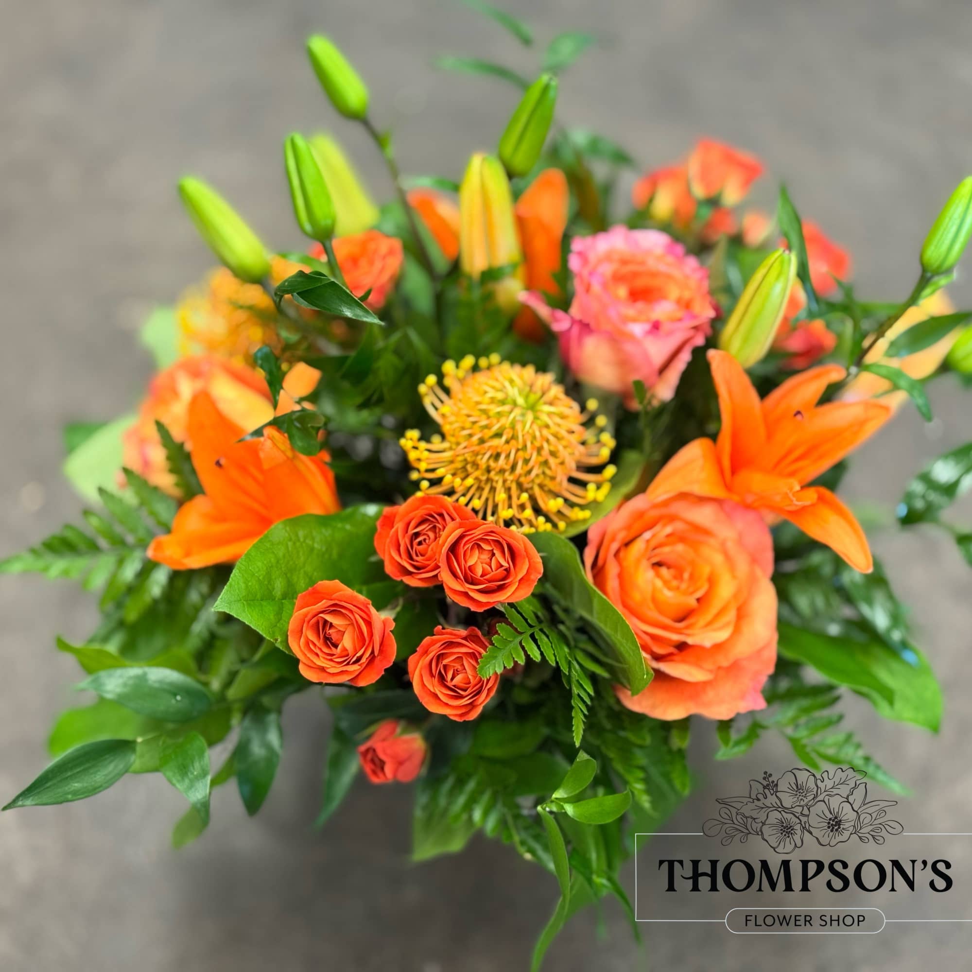 A monochromatic mix of oranges that includes pin-cushion protea, free spirit roses A monochromatic mix of oranges that includes pin-cushion protea, free spirit roses