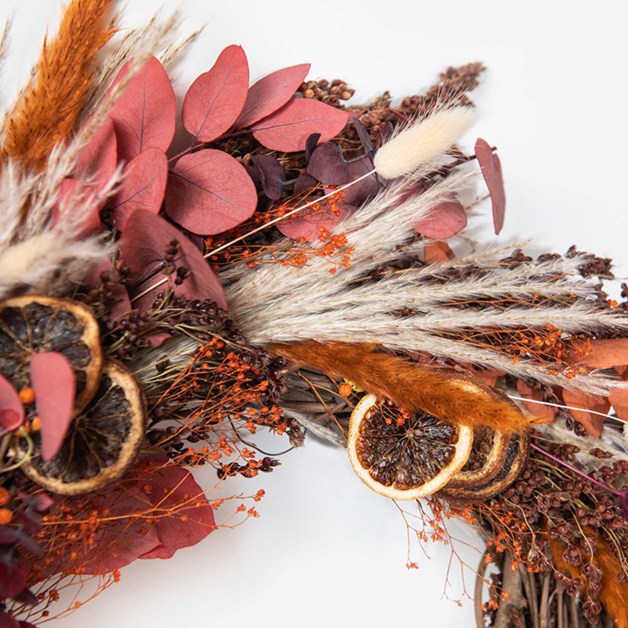 This hand-made, asymmetrical wreath includes an assortment of dried florals and citrus This hand-made, asymmetrical wreath includes an assortment of dried florals and citrus