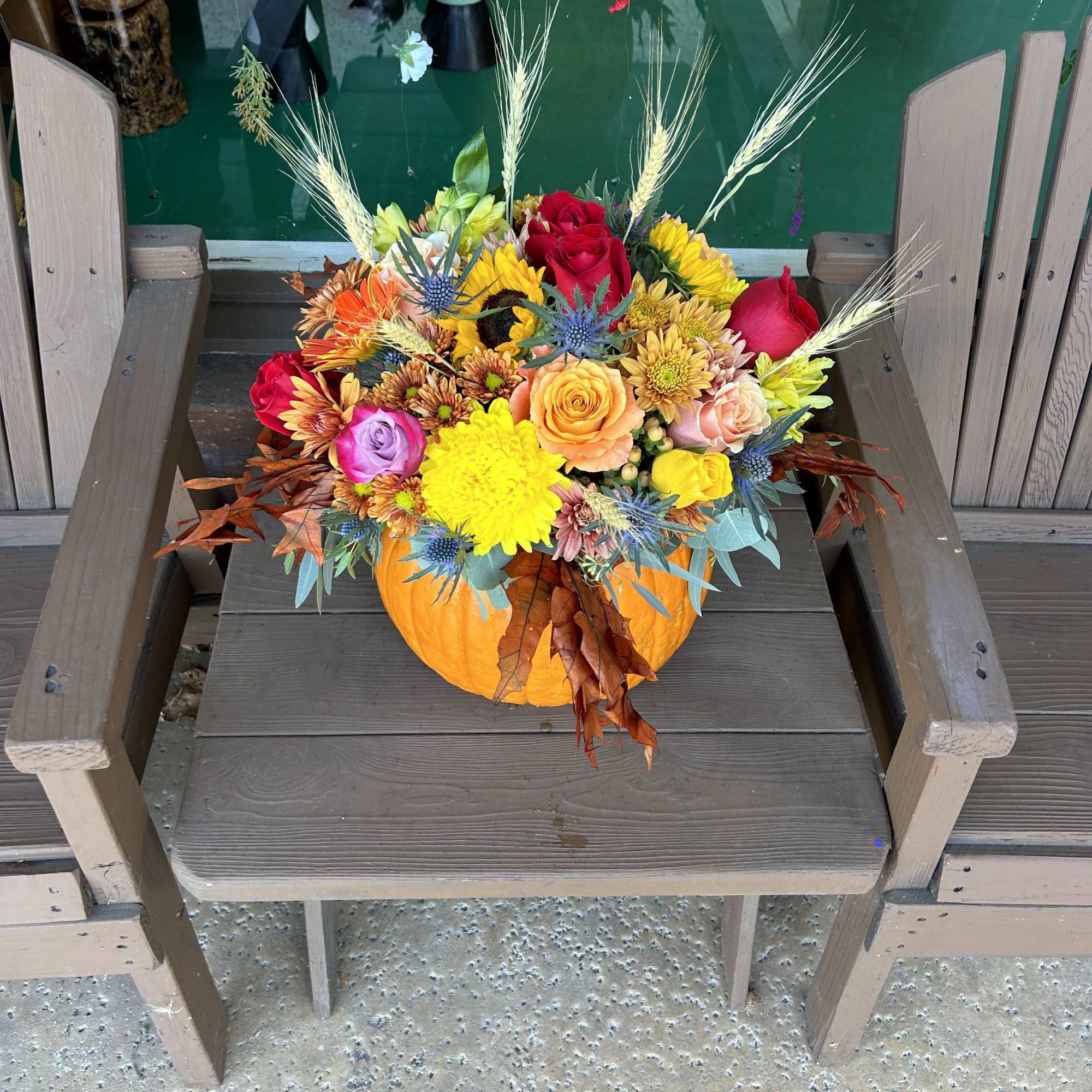 &ldquo;A stunning oversized pumpkin centerpiece, overflowing with lush seasonal blooms and greenery.