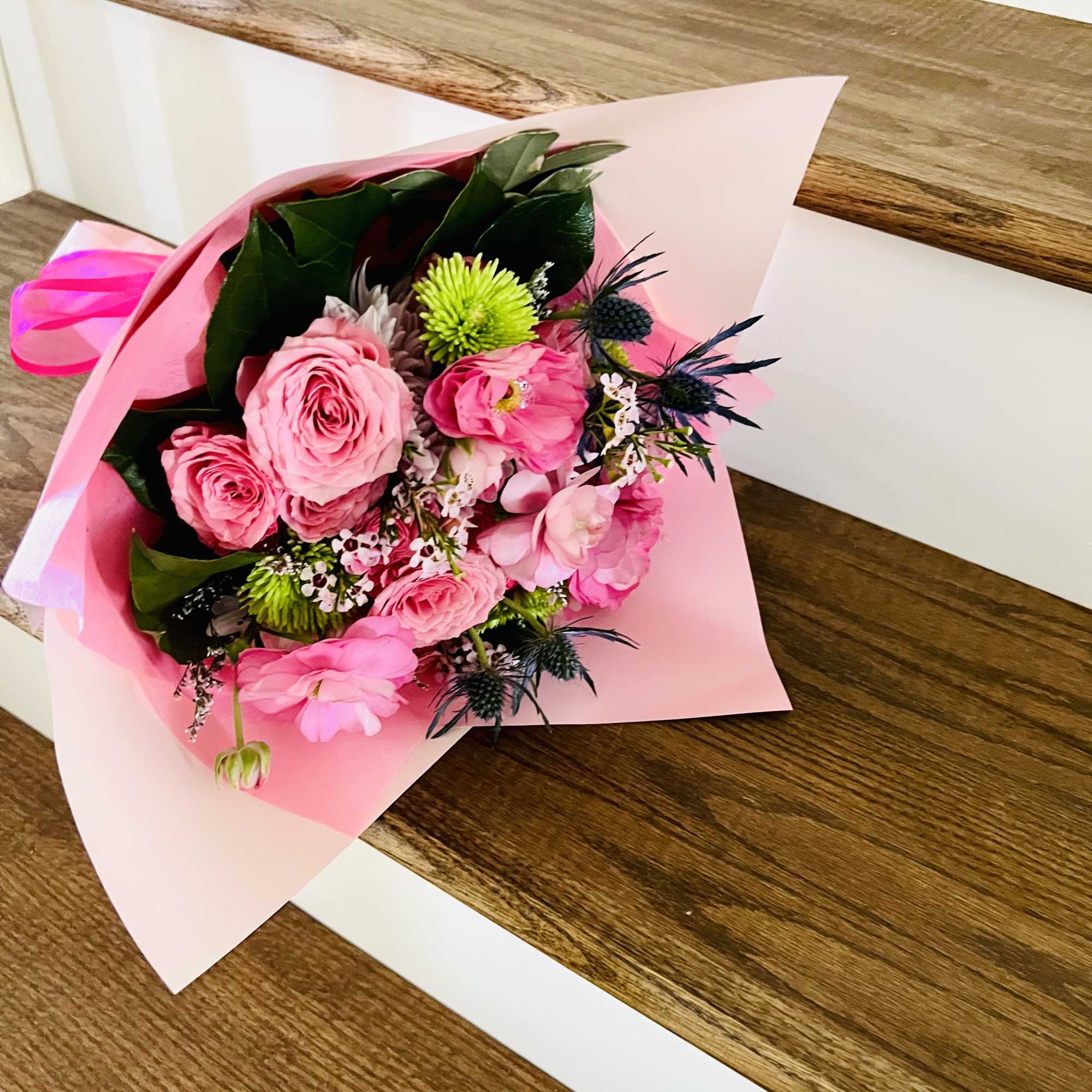 A designer&rsquo;s choice wrapped bouquet featuring 5 radiant roses paired with premium